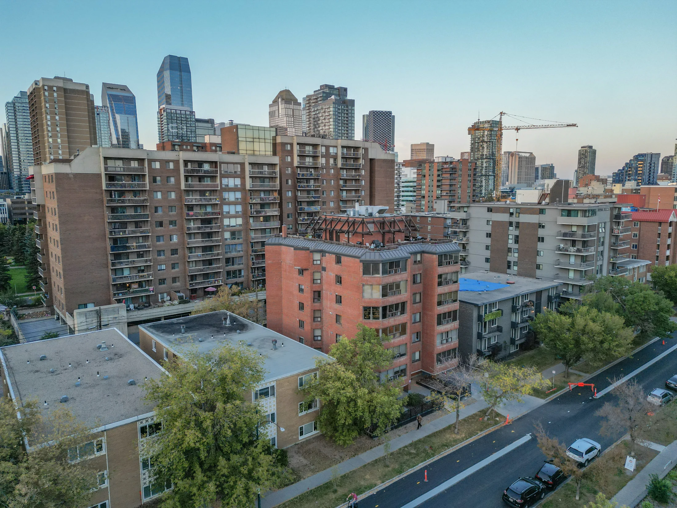 Aerial of brick apartment buildings with downtown towers behind
