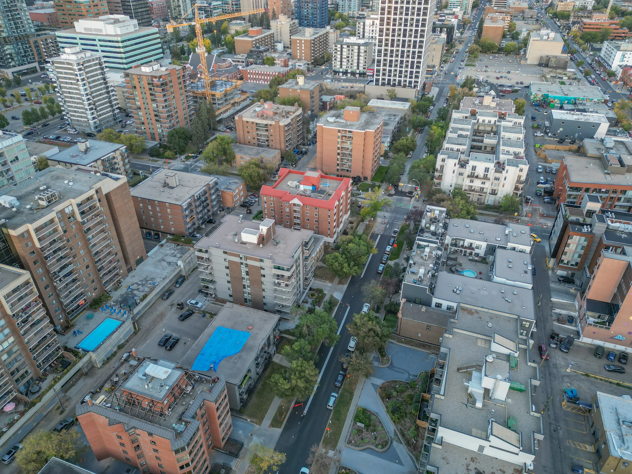 Aerial of low-rise apartments with rooftop pools and trees