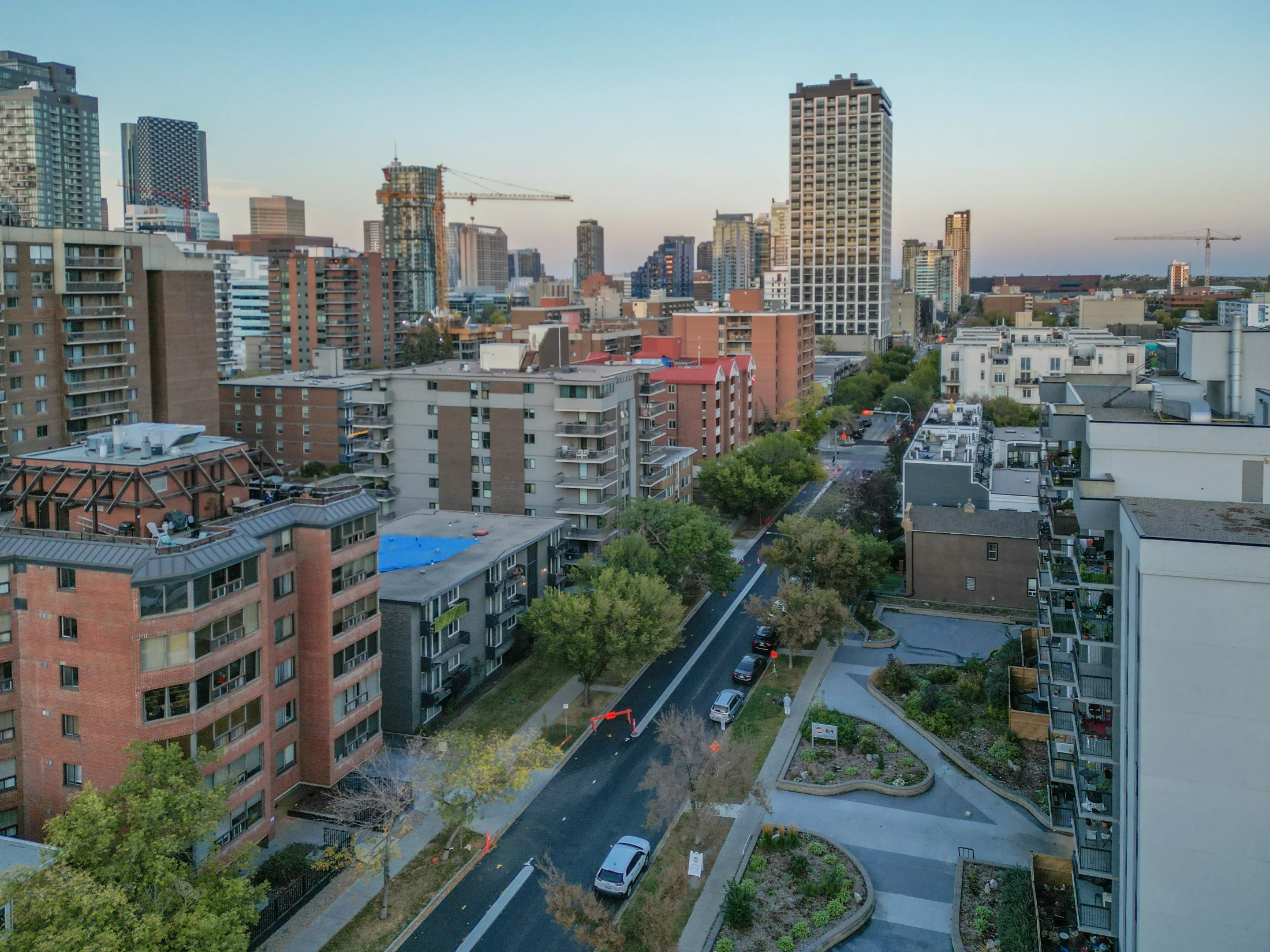 Aerial of older apartment buildings along a tree-lined road
