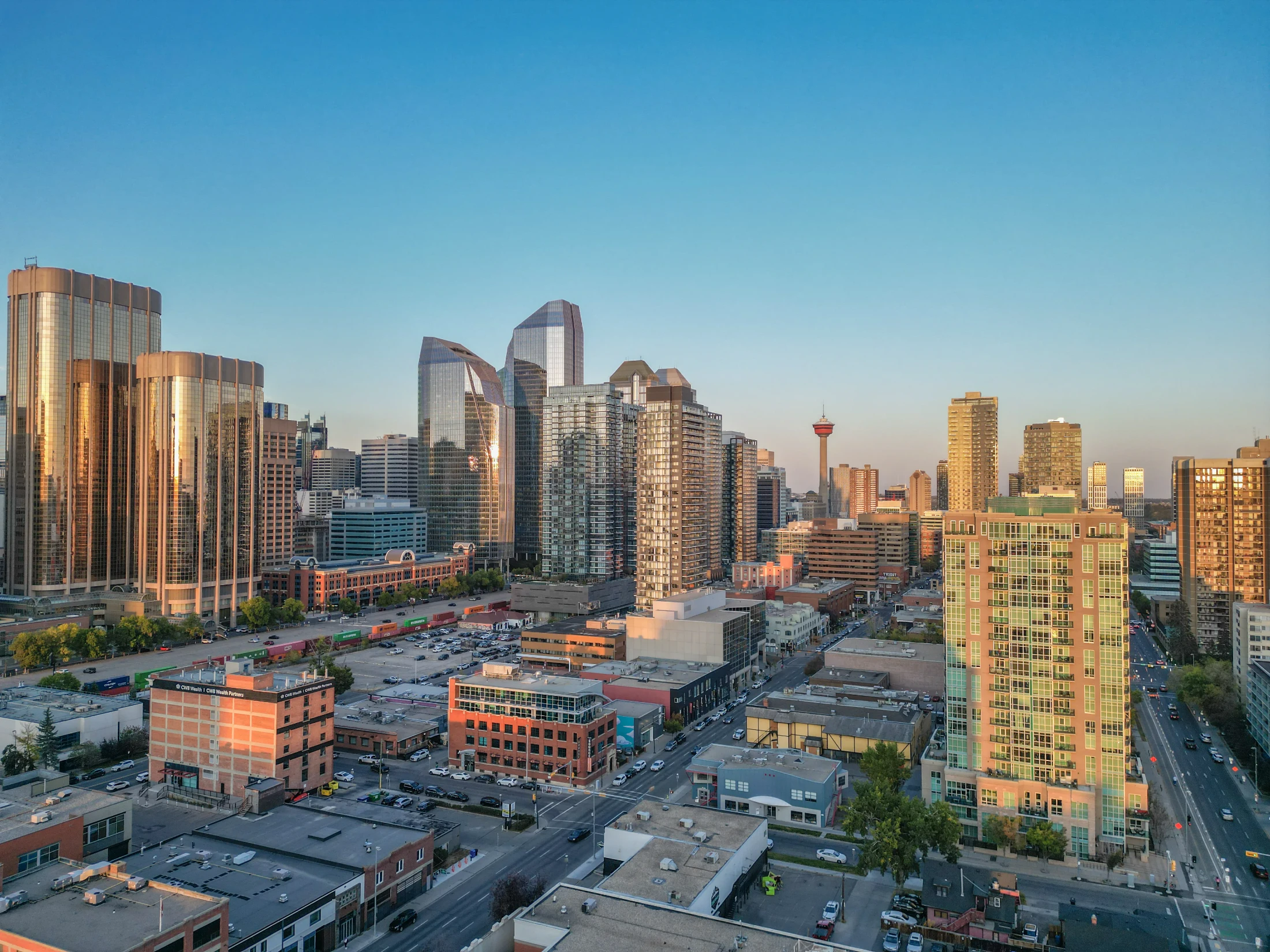 Glass condo towers at sunset with the Calgary Tower in the distance