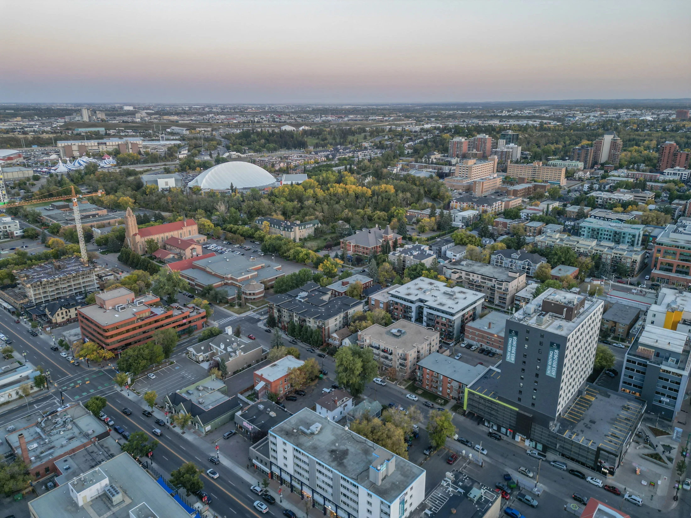 Aerial of inner-city streets with low-rise apartments and the Saddledome