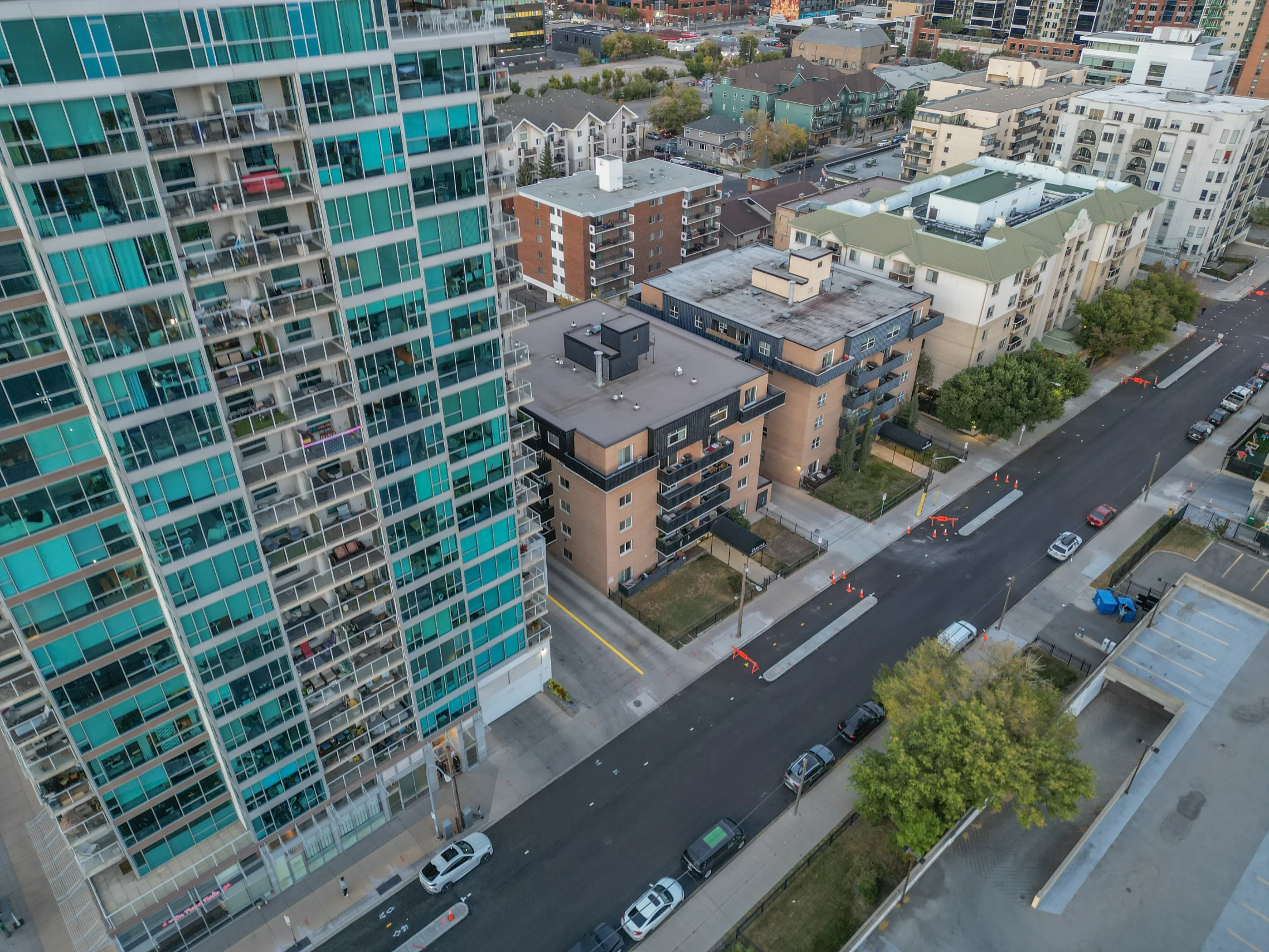 Aerial of a glass condo tower above low-rise apartments