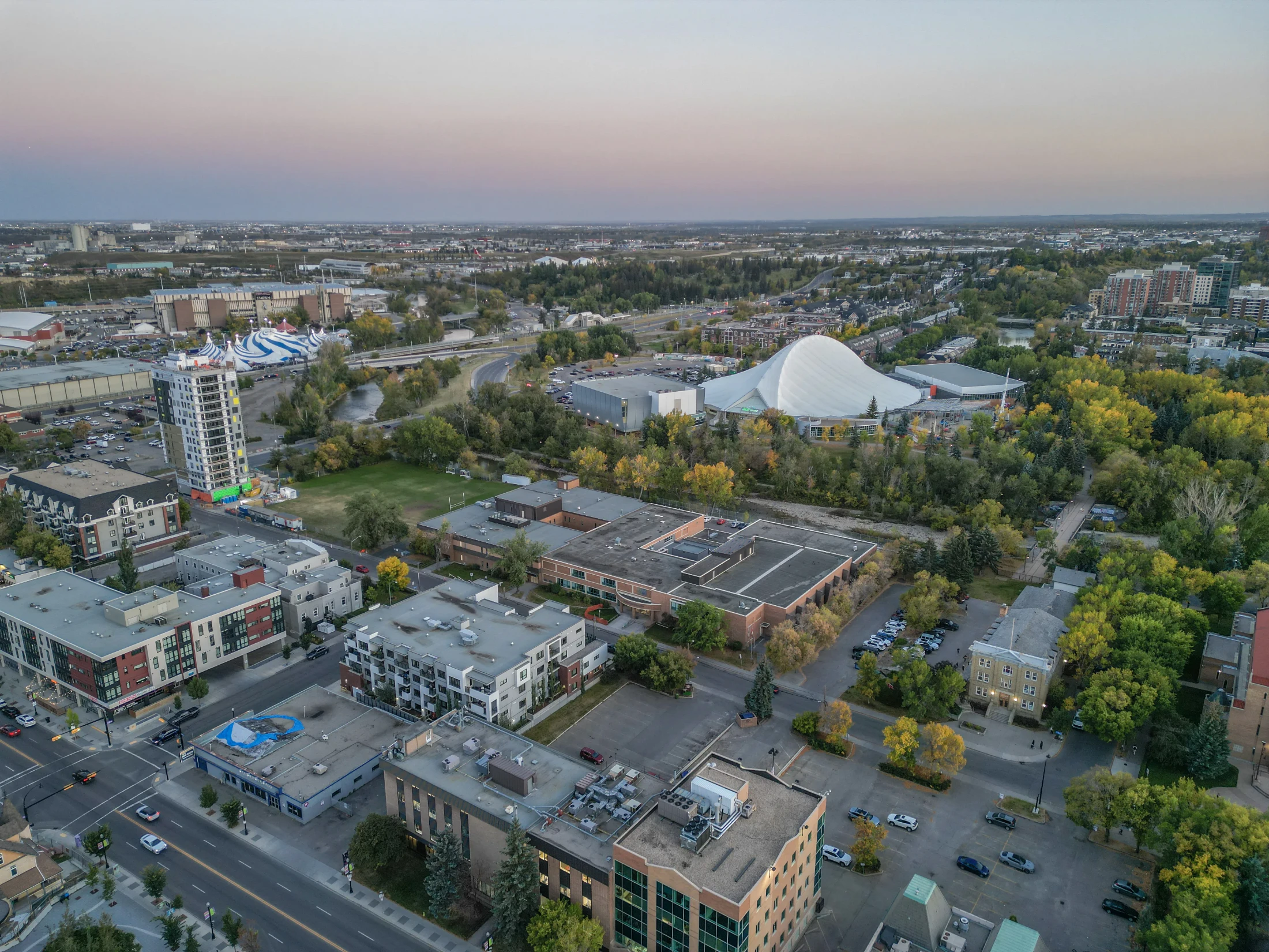 Aerial of an inner-city area with parks, apartments and the Saddledome roof