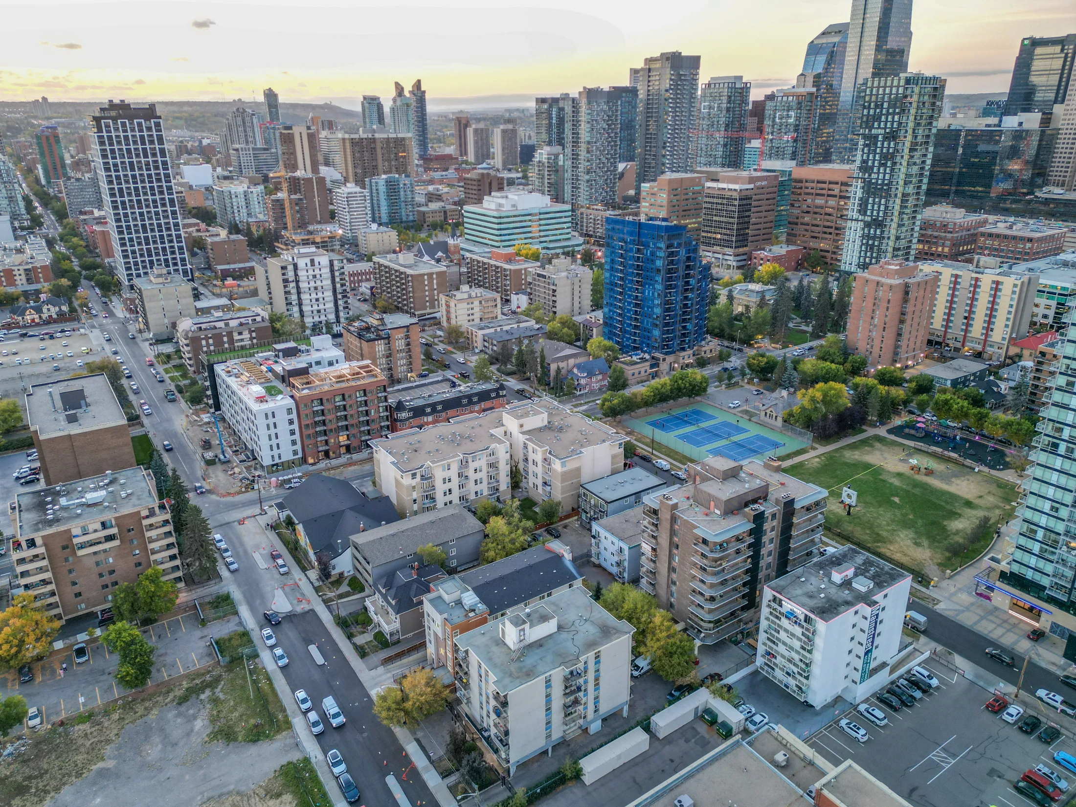 Aerial of apartments, a tennis court and green space near downtown