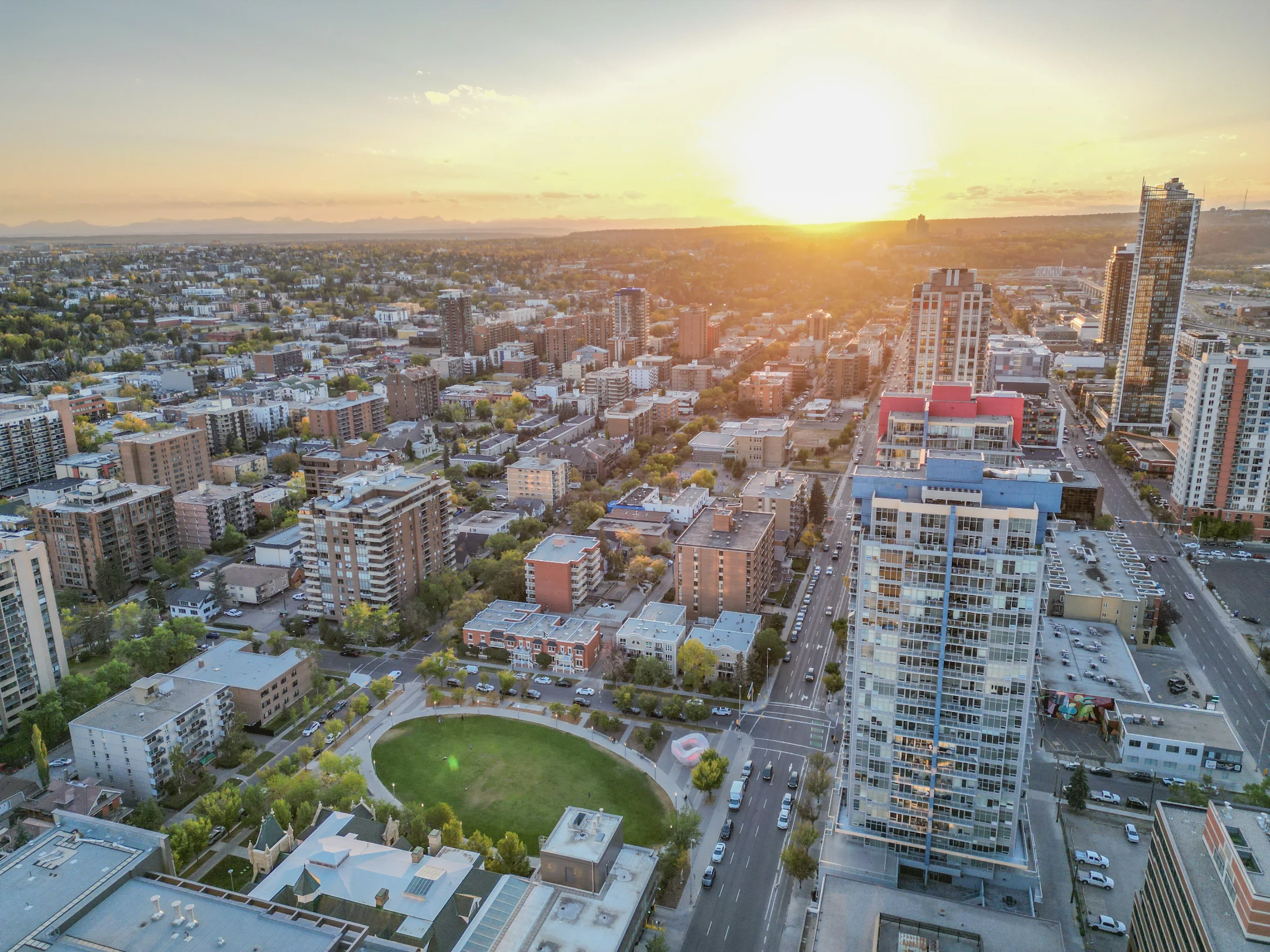 Aerial of high-rises and a green park at sunset