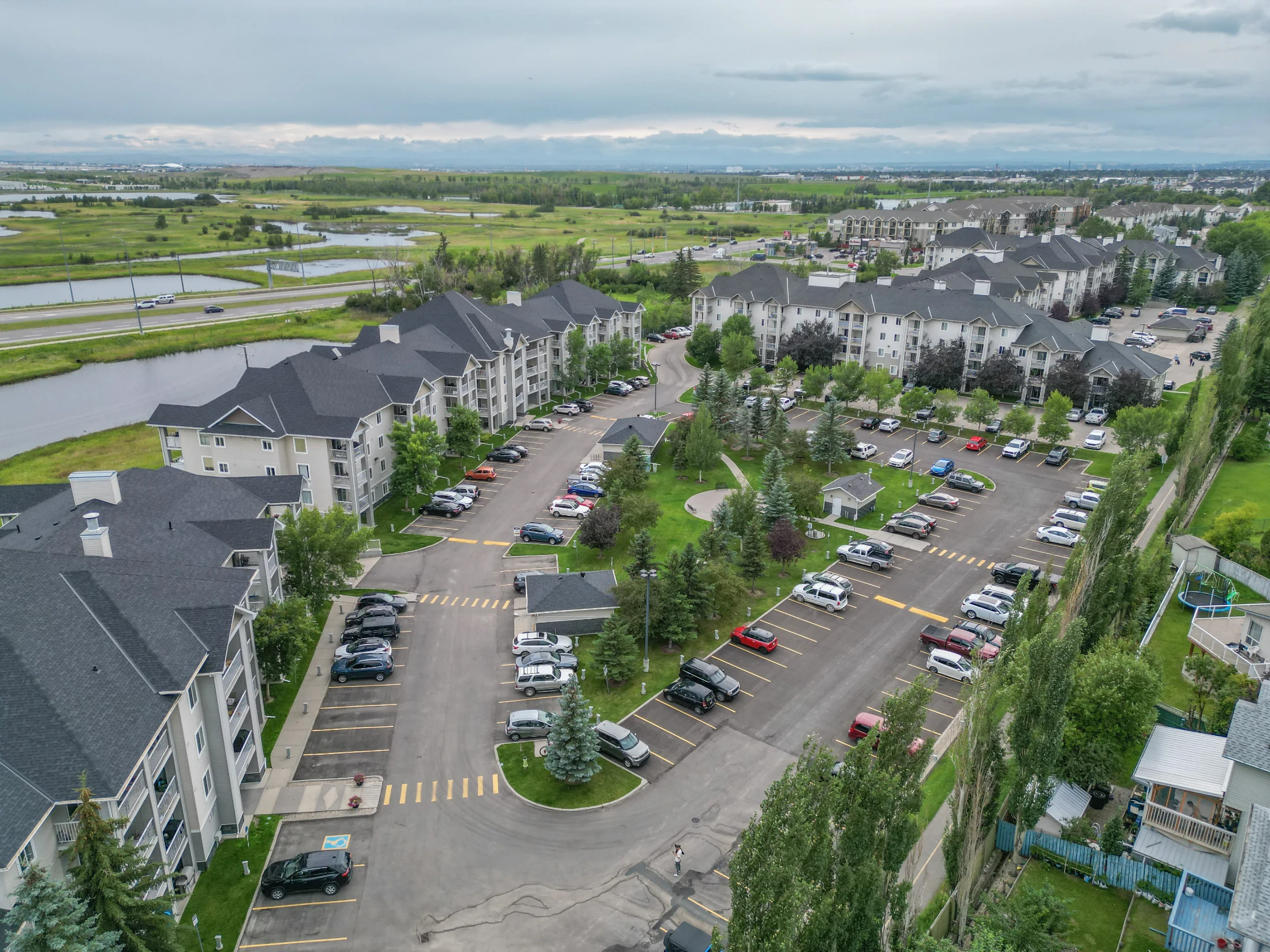 Aerial of a condo and townhome complex with parking and green space