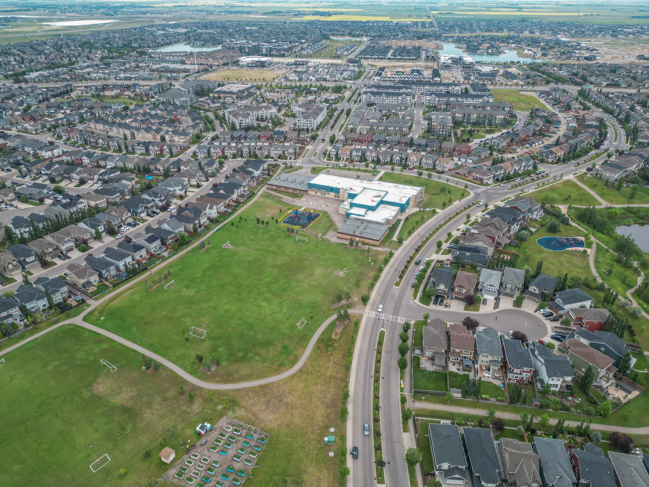 Aerial view of detached homes and open green space on Calgary's west side