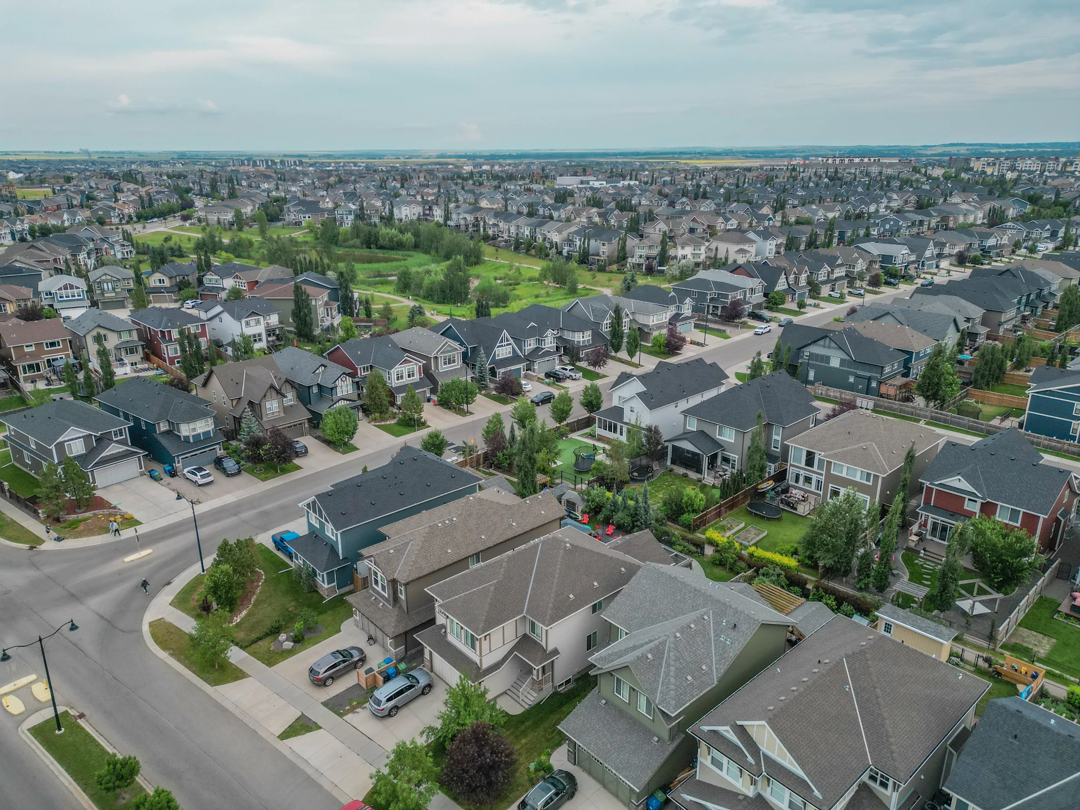 Aerial view of detached homes and treed backyards in north Calgary