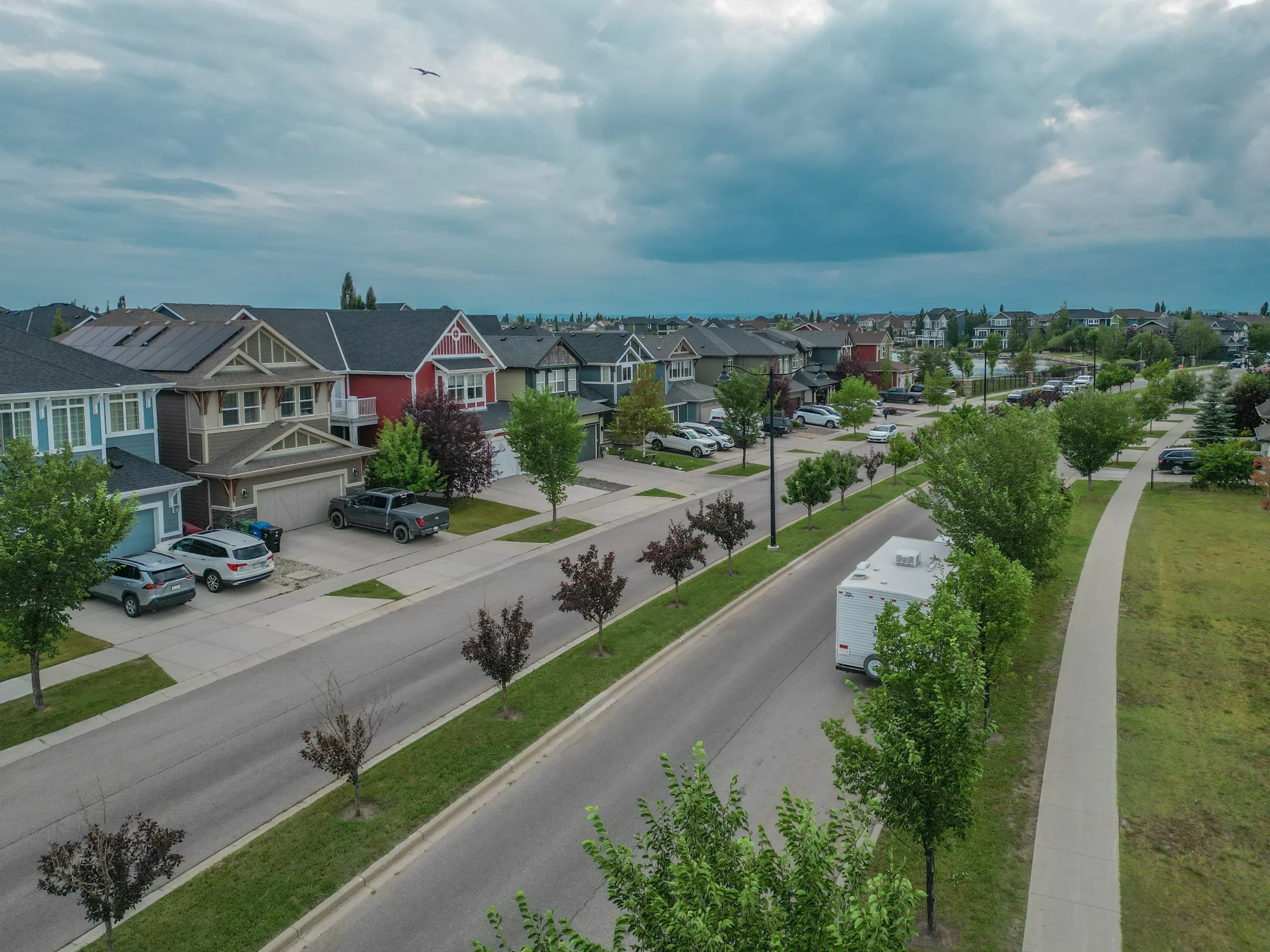 A residential street with a pathway and green boulevard in north Calgary