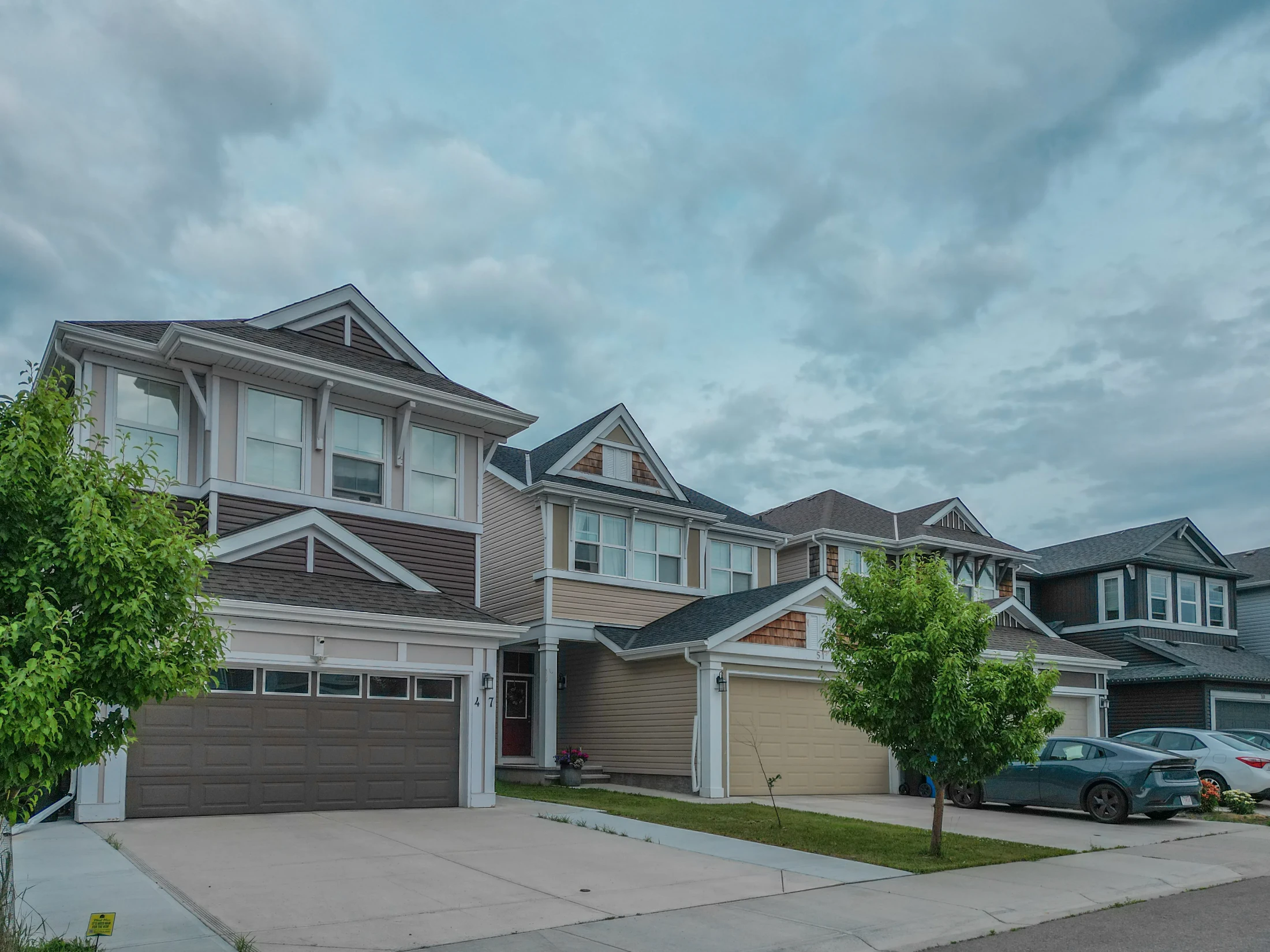 Front-garage family homes along a quiet north Calgary street