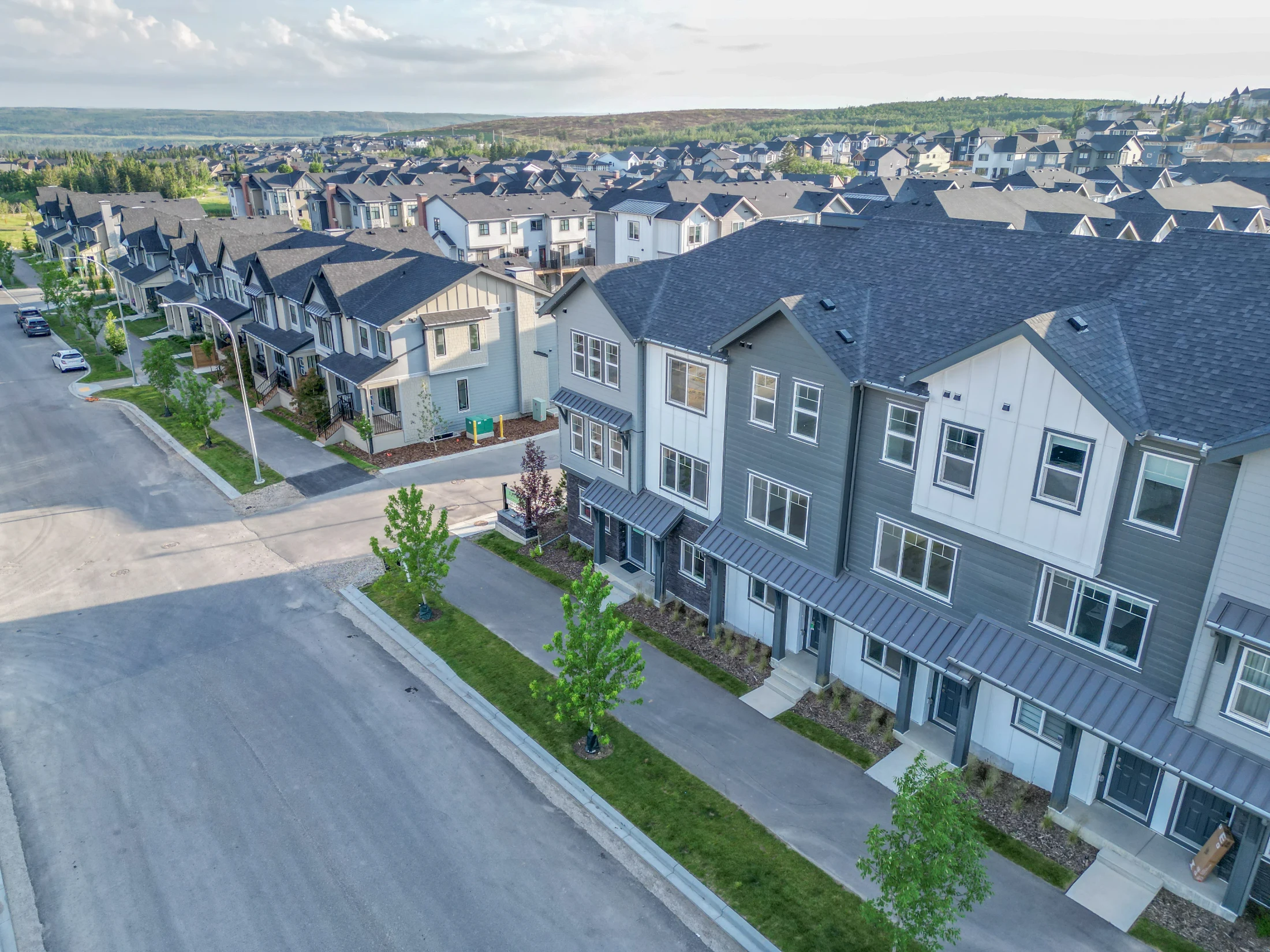 Three-storey townhomes with grey siding in Aspen Woods, Calgary