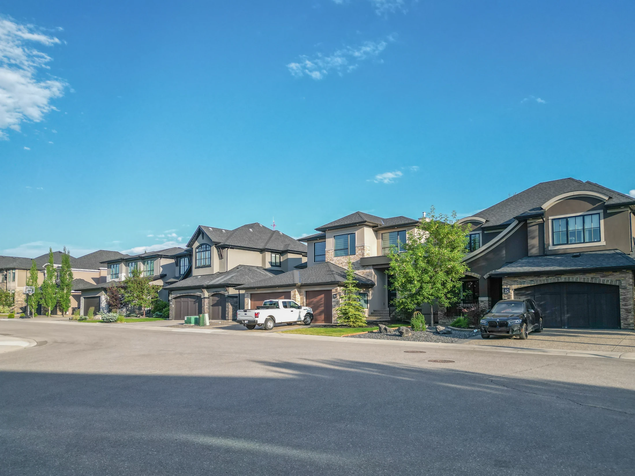 Two-storey homes with double garages along a sunny street