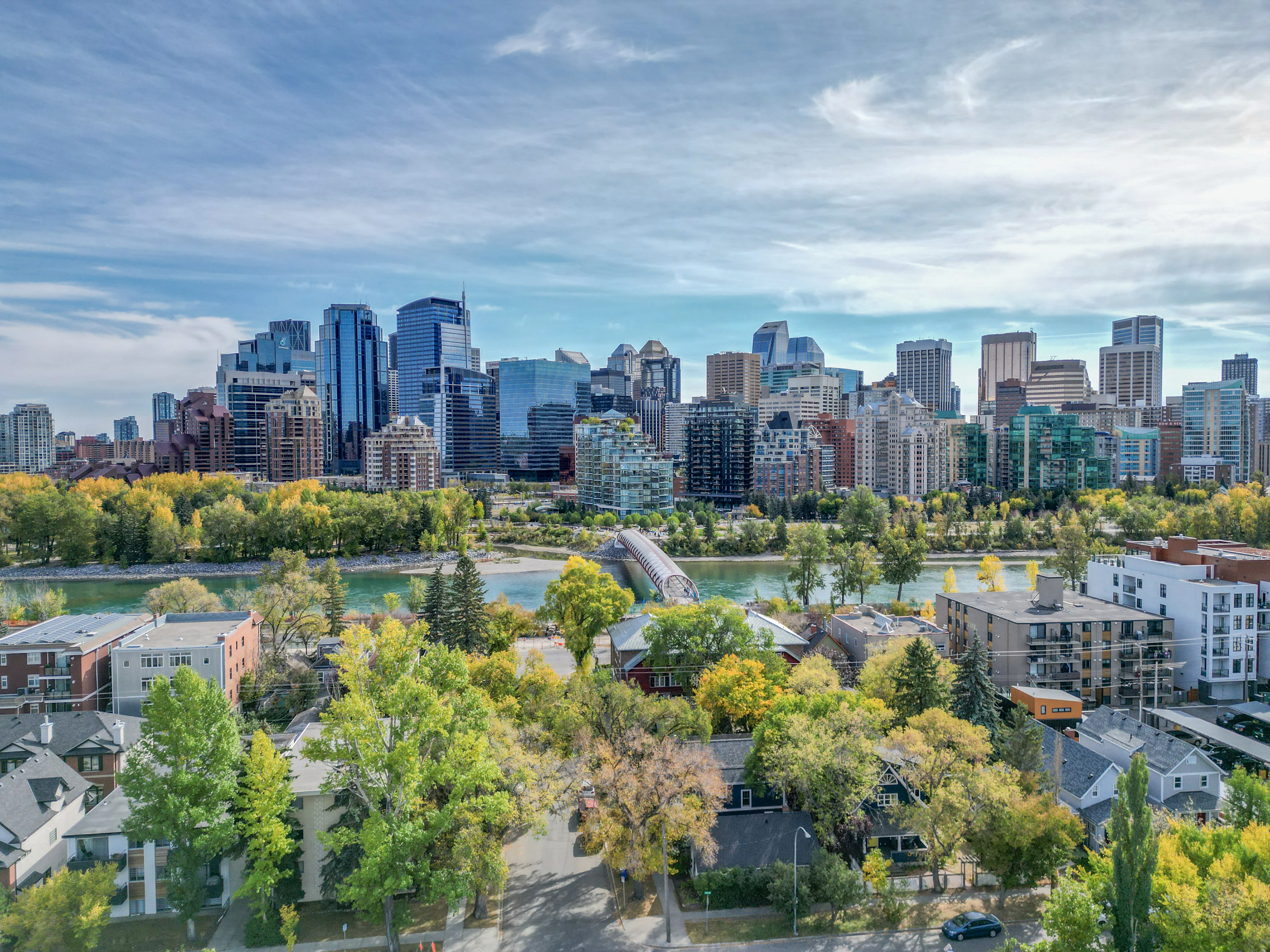 Bow River pathway and footbridge with inner-city homes and downtown towers
