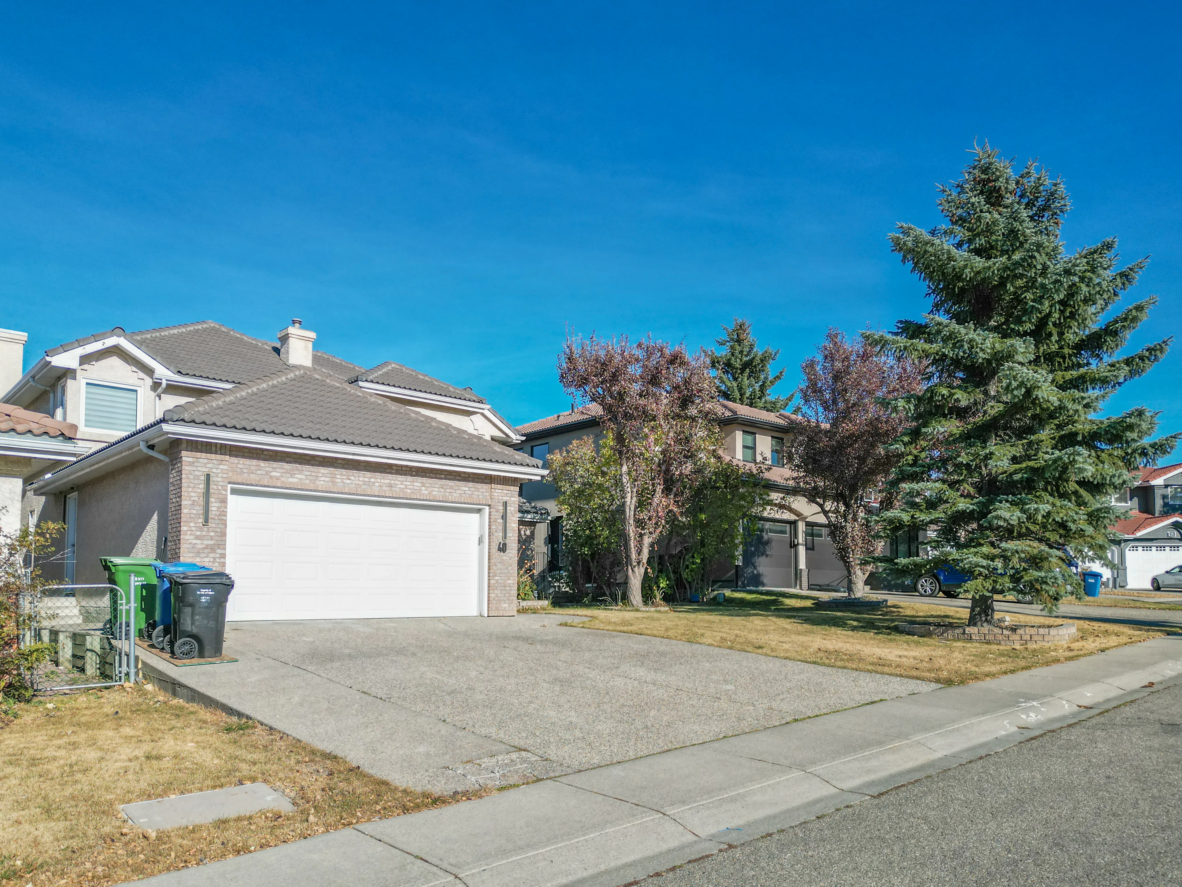 Two-storey home with a white garage door and a front lawn