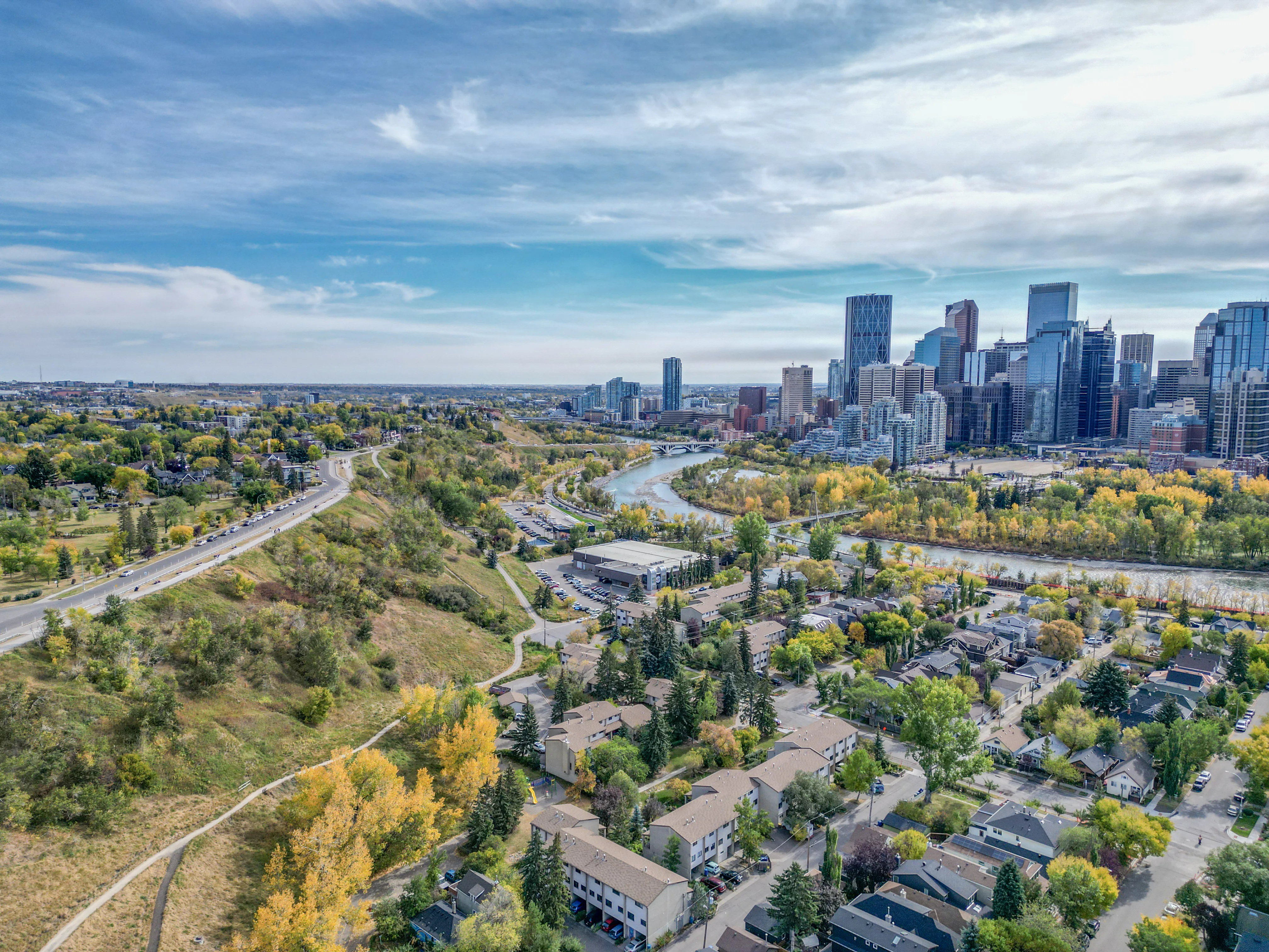 Hillside homes among mature trees with a view of the downtown skyline