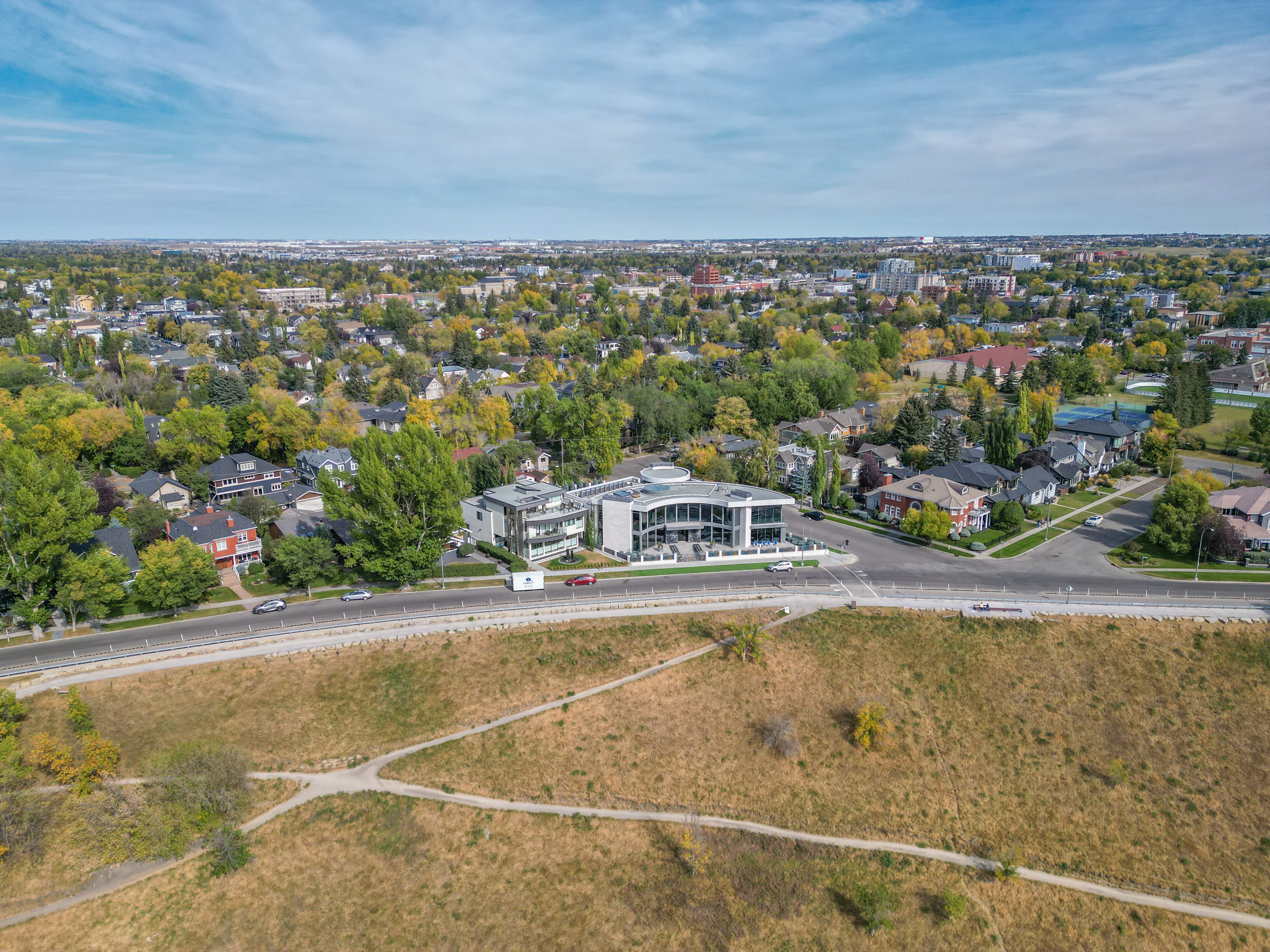 Grassy hillside park with pathways and homes beyond