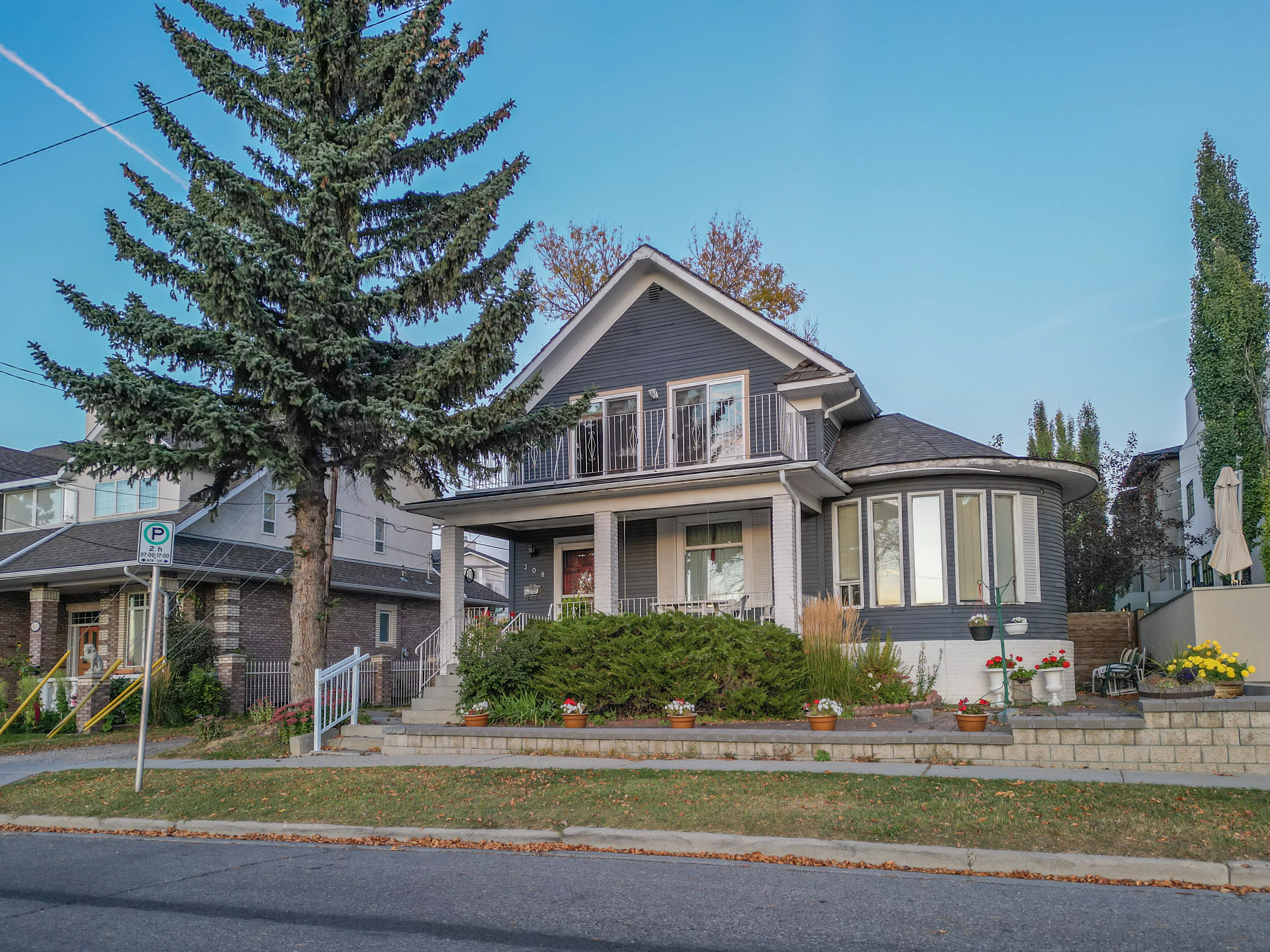 Character home with a deep front garden behind a tall spruce