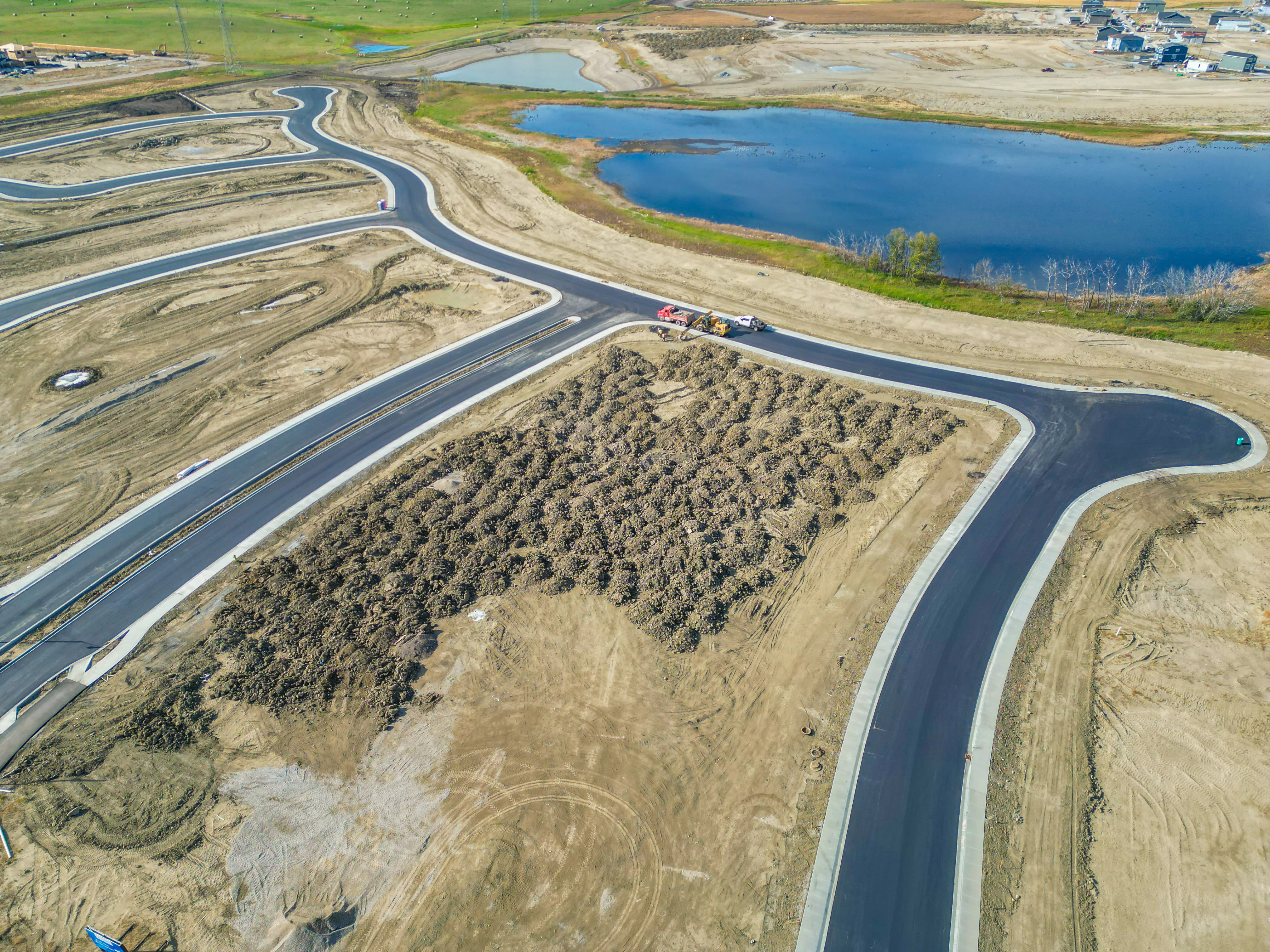 Aerial of natural grassland beside a curving residential road