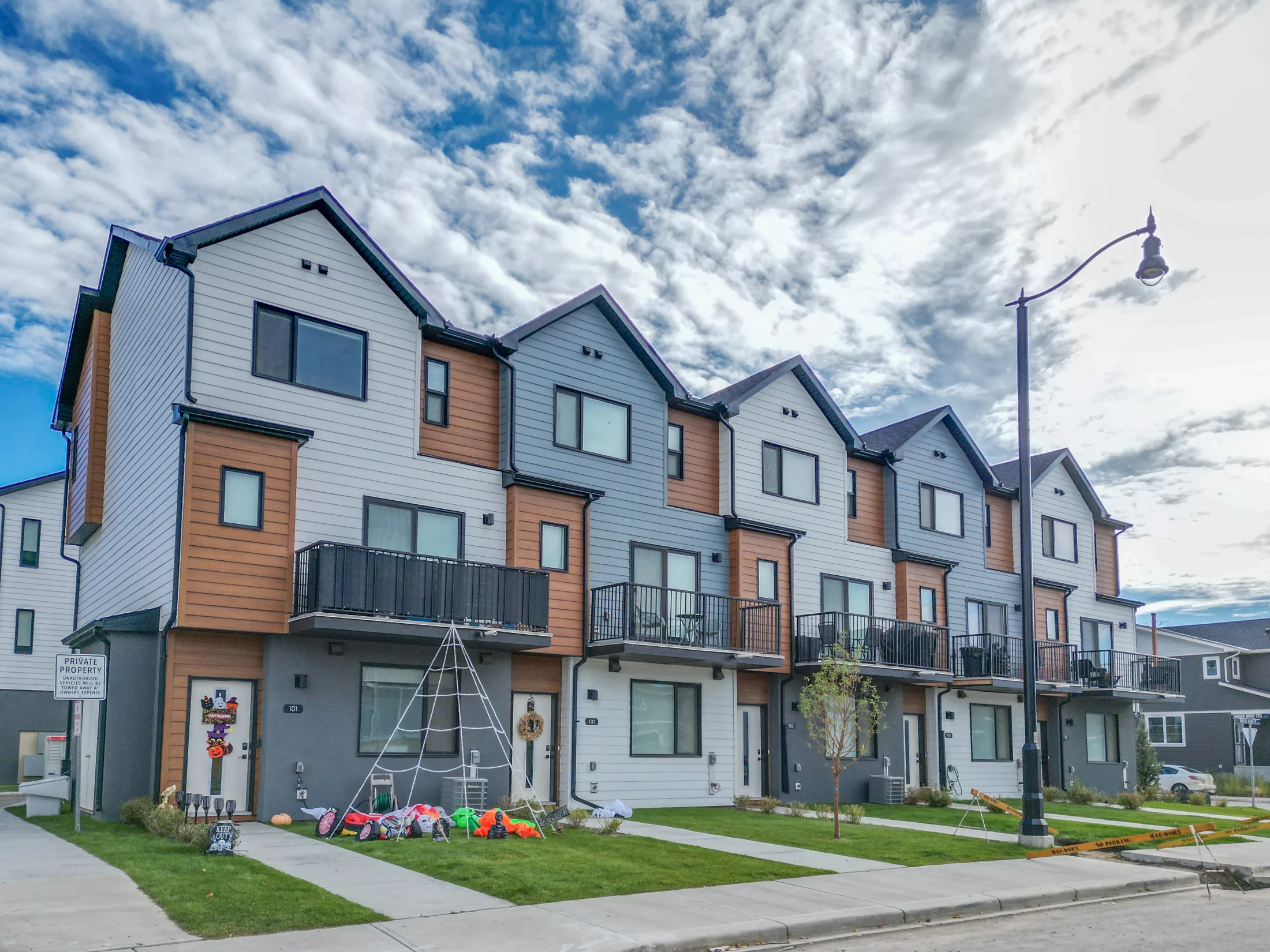 Row of modern townhomes with front steps and young street trees