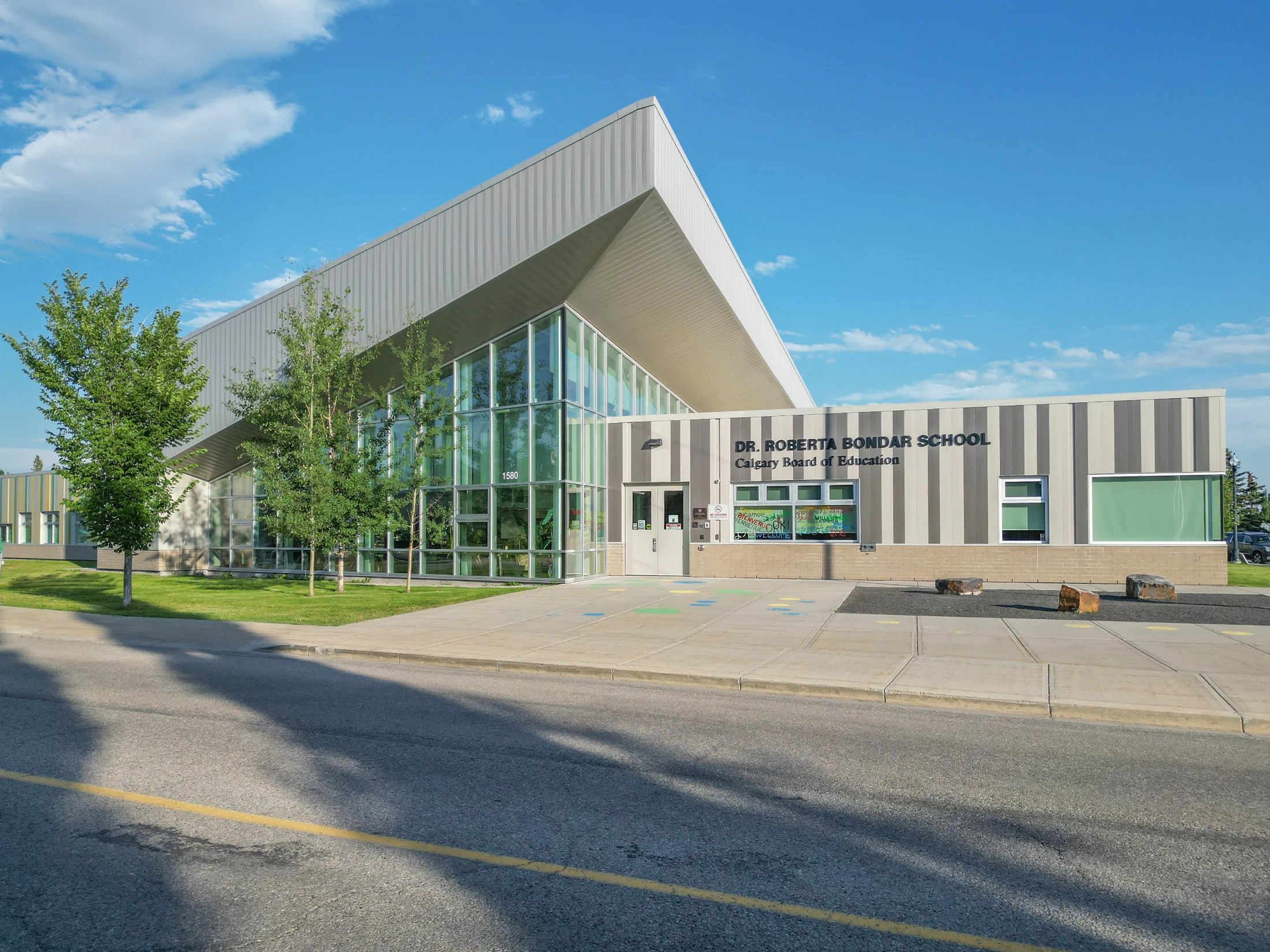 Modern school building with a curved roof and landscaped grounds