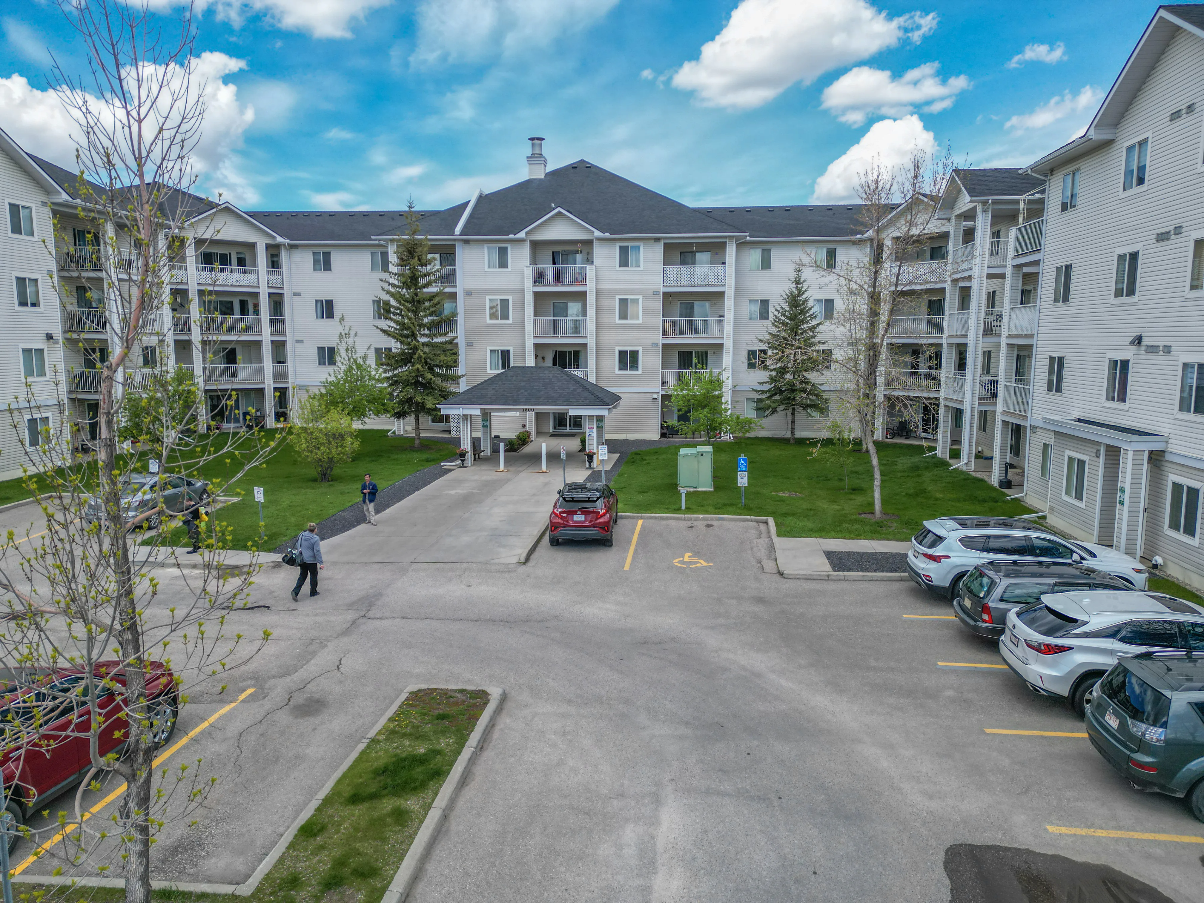 Condo building with a covered entrance and lawns on both sides