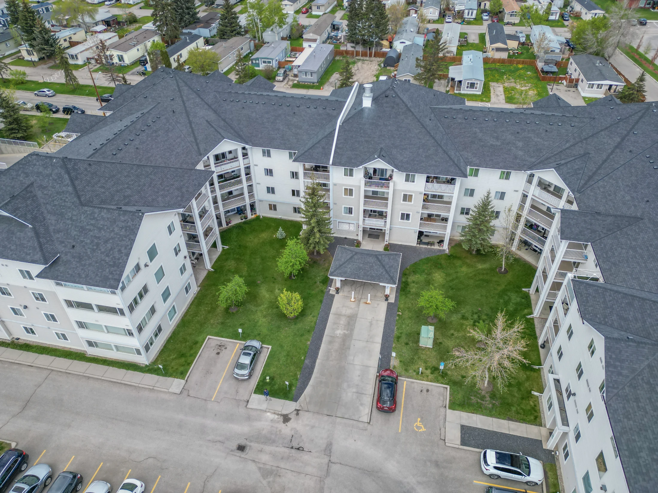 Aerial of a large condo building with a landscaped courtyard