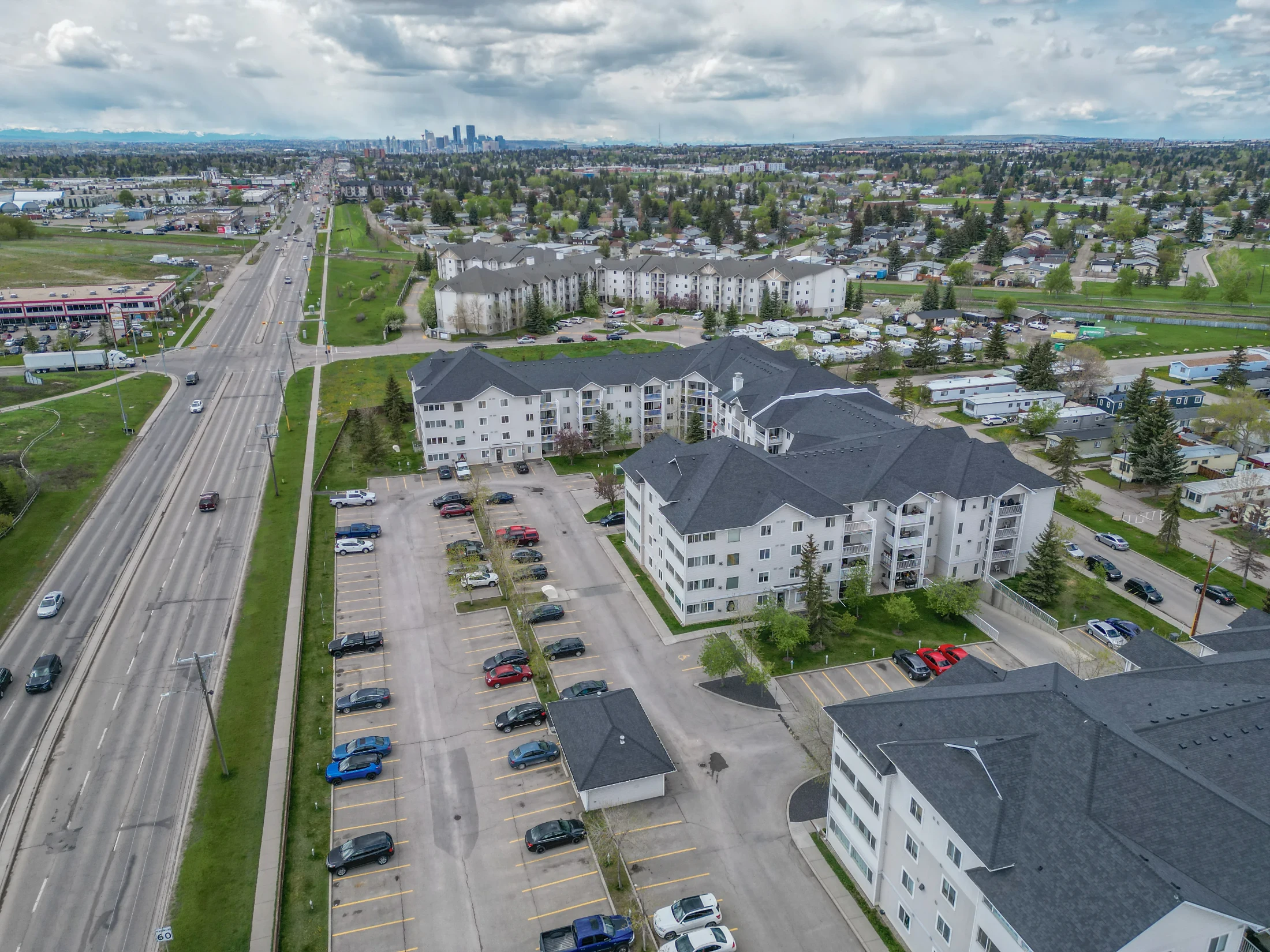Aerial of low-rise condo buildings beside a main road