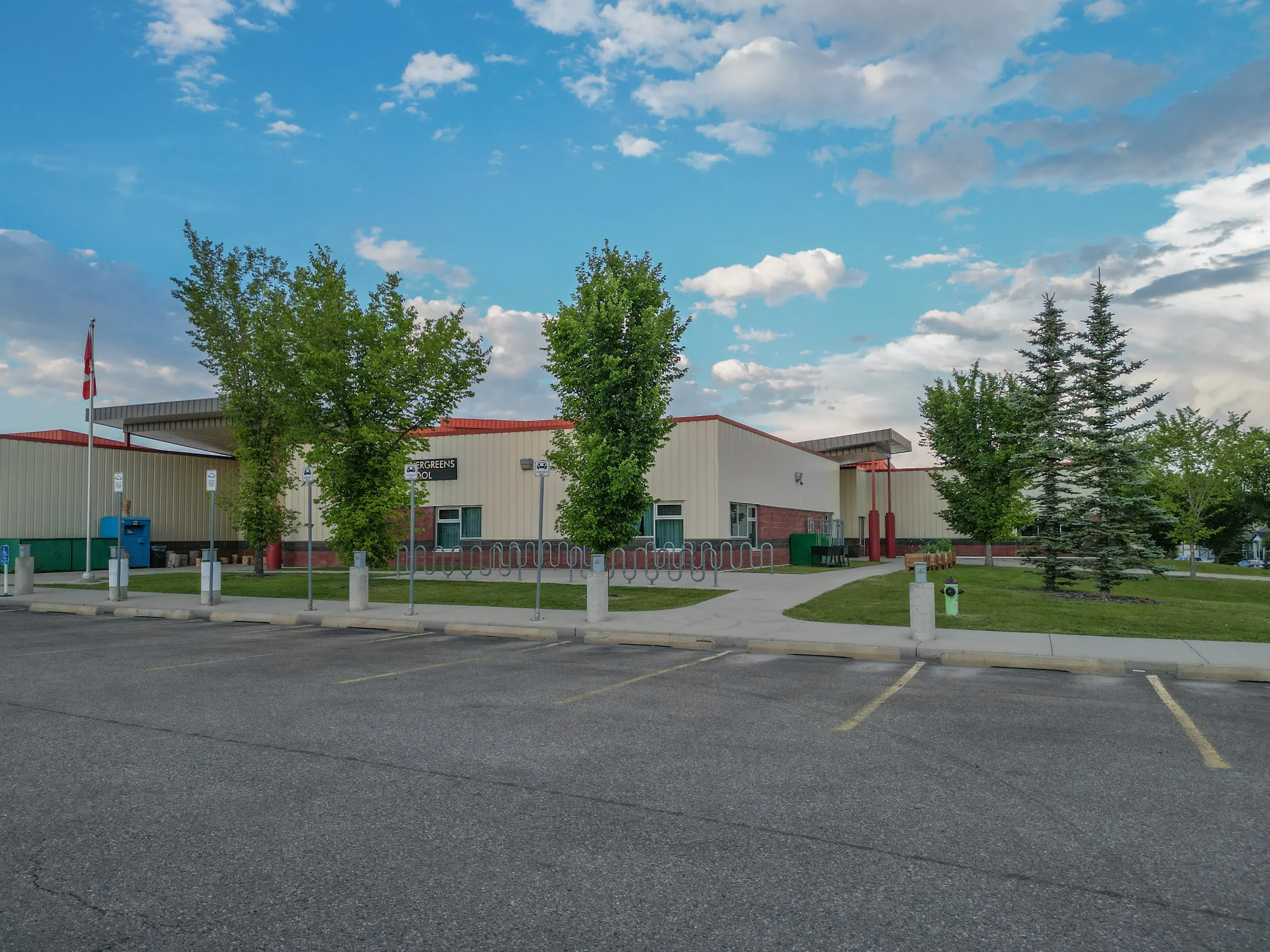 School building with trees along a parking lot