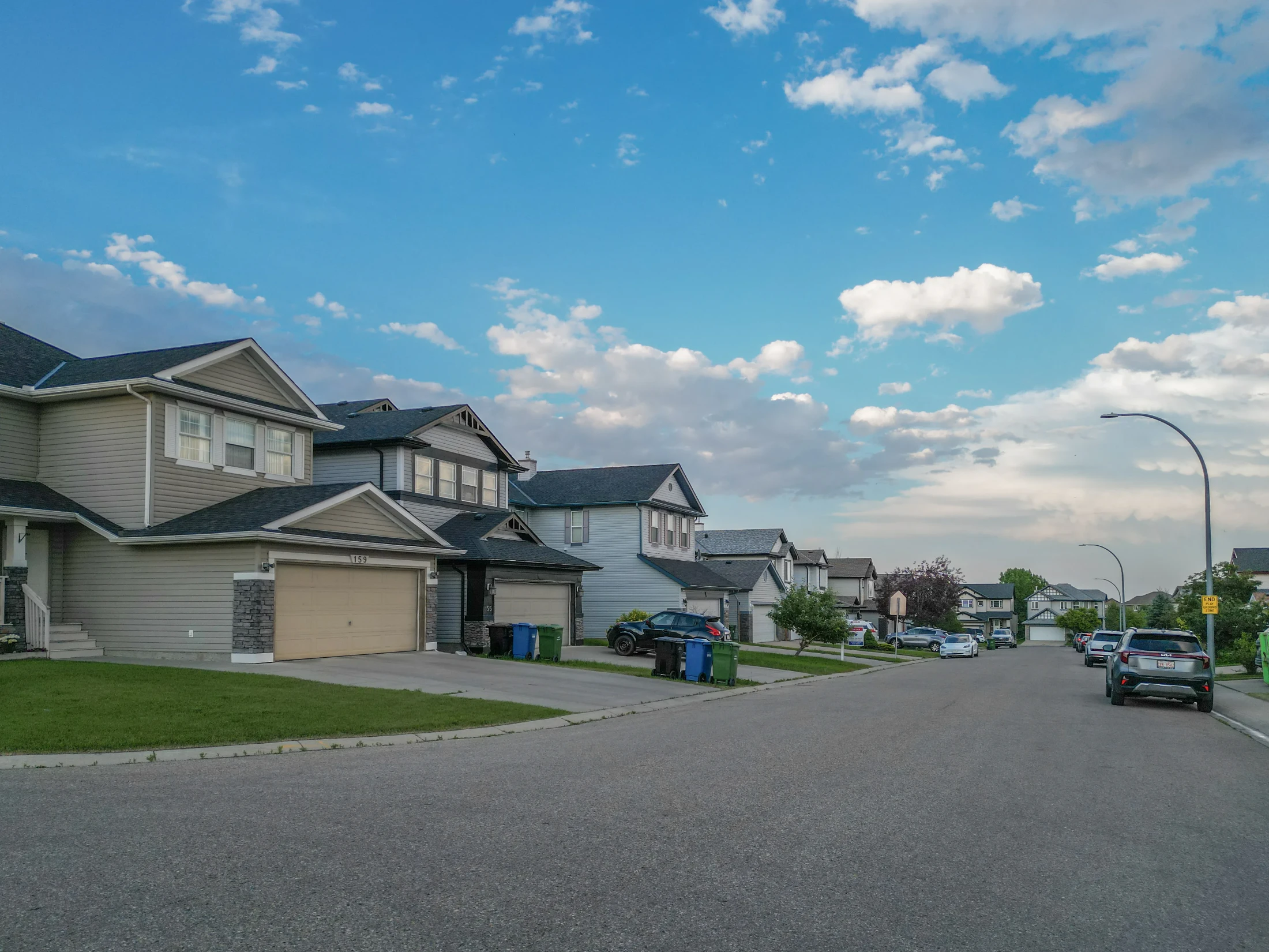 Two-storey homes with front garages along a quiet suburban street