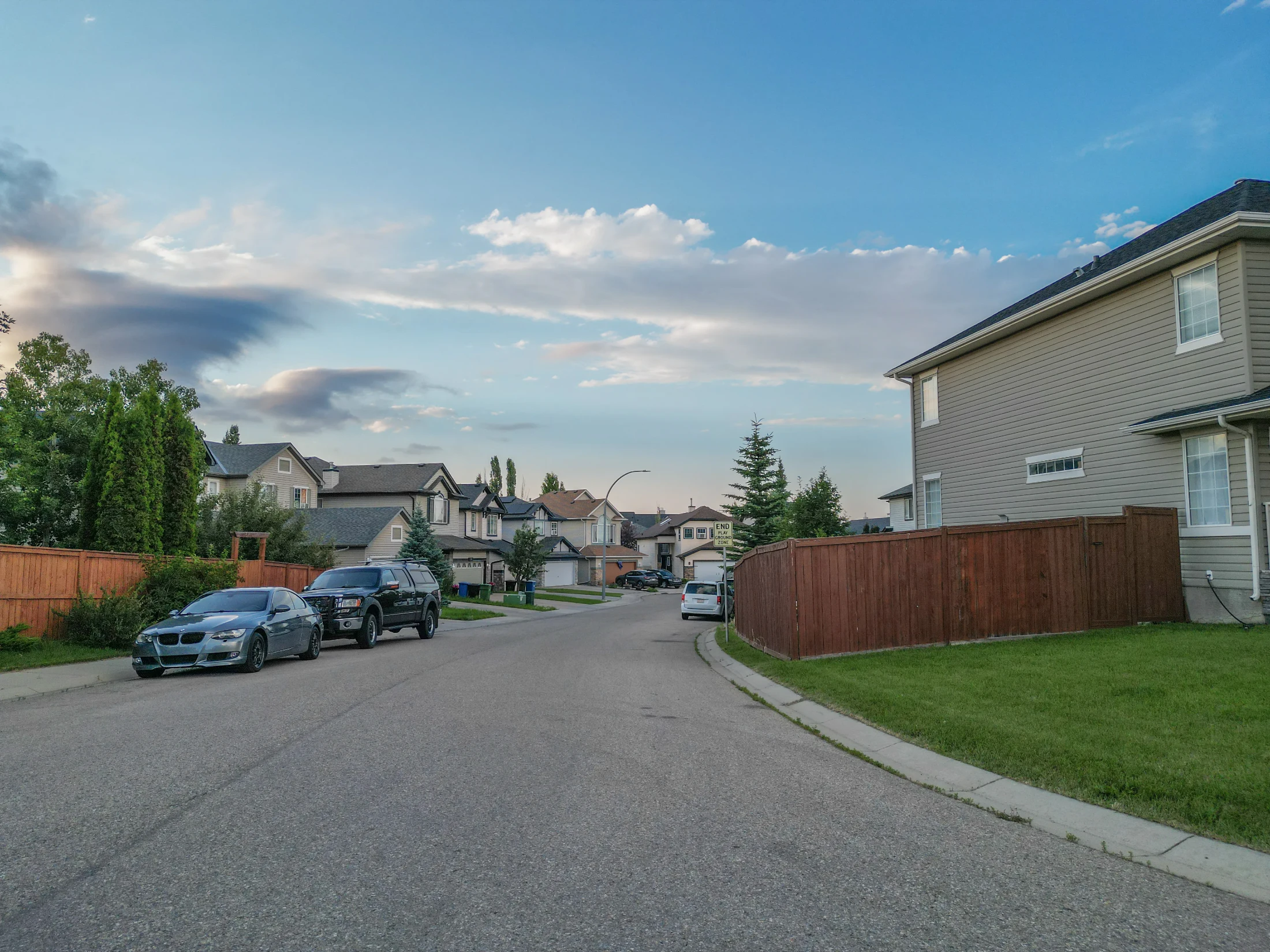 Two-storey homes and front driveways along a curving suburban street