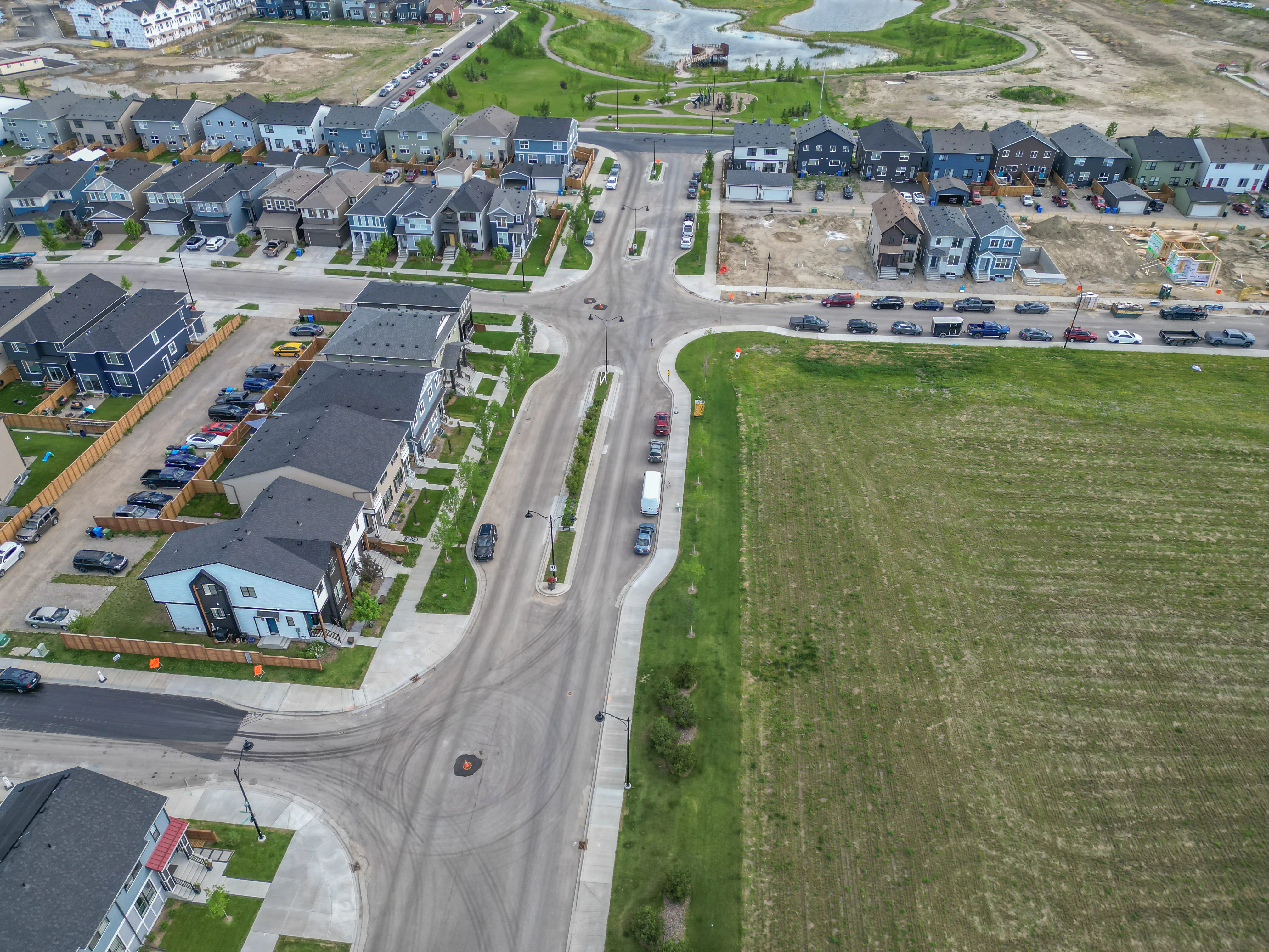 Aerial of new homes beside open land and a wide road