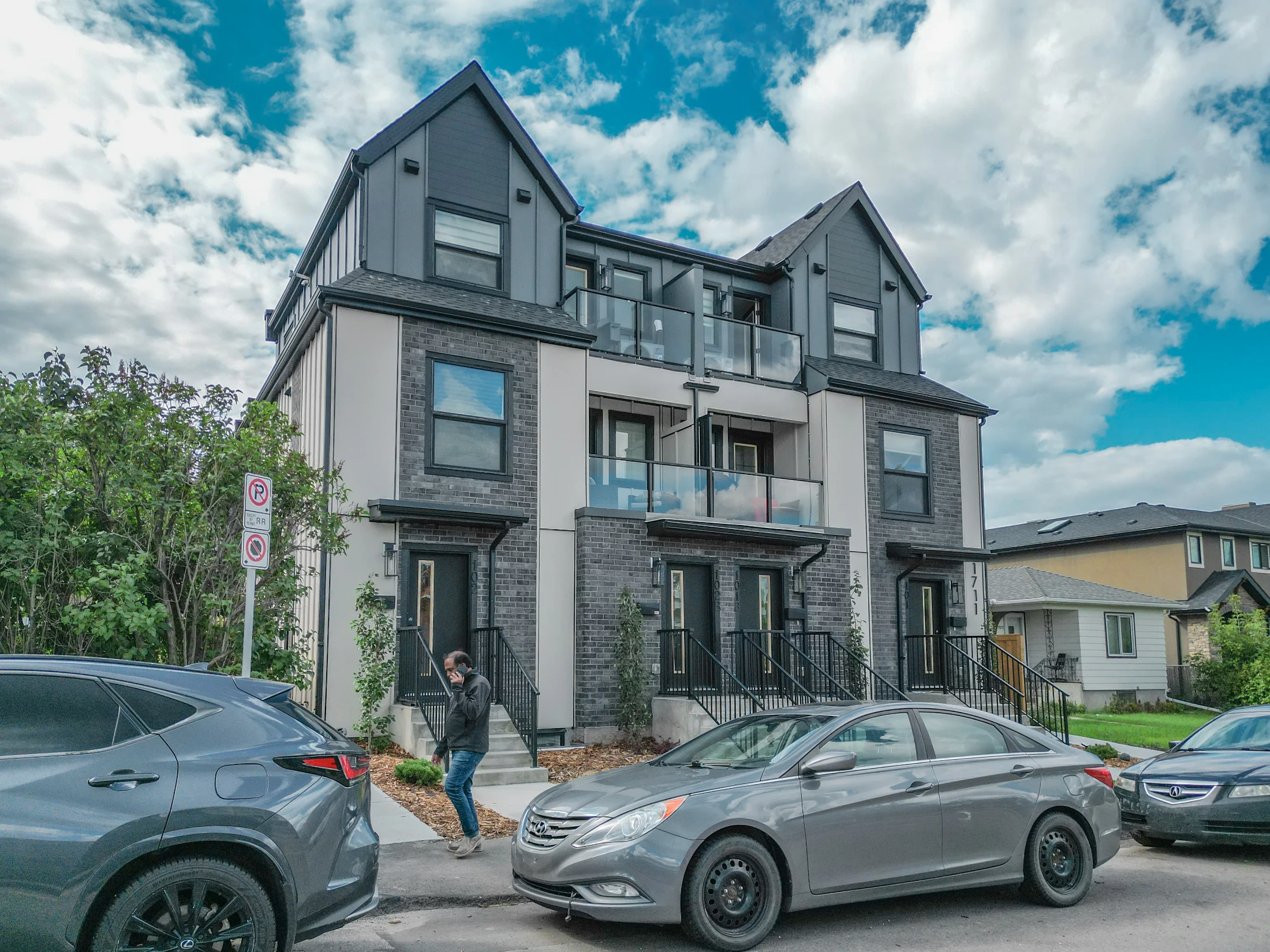 New luxury home with stone and dark siding on an established street
