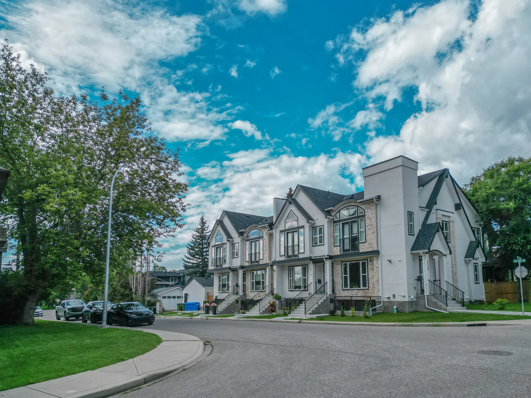 Row of new townhomes on a corner lot with young trees