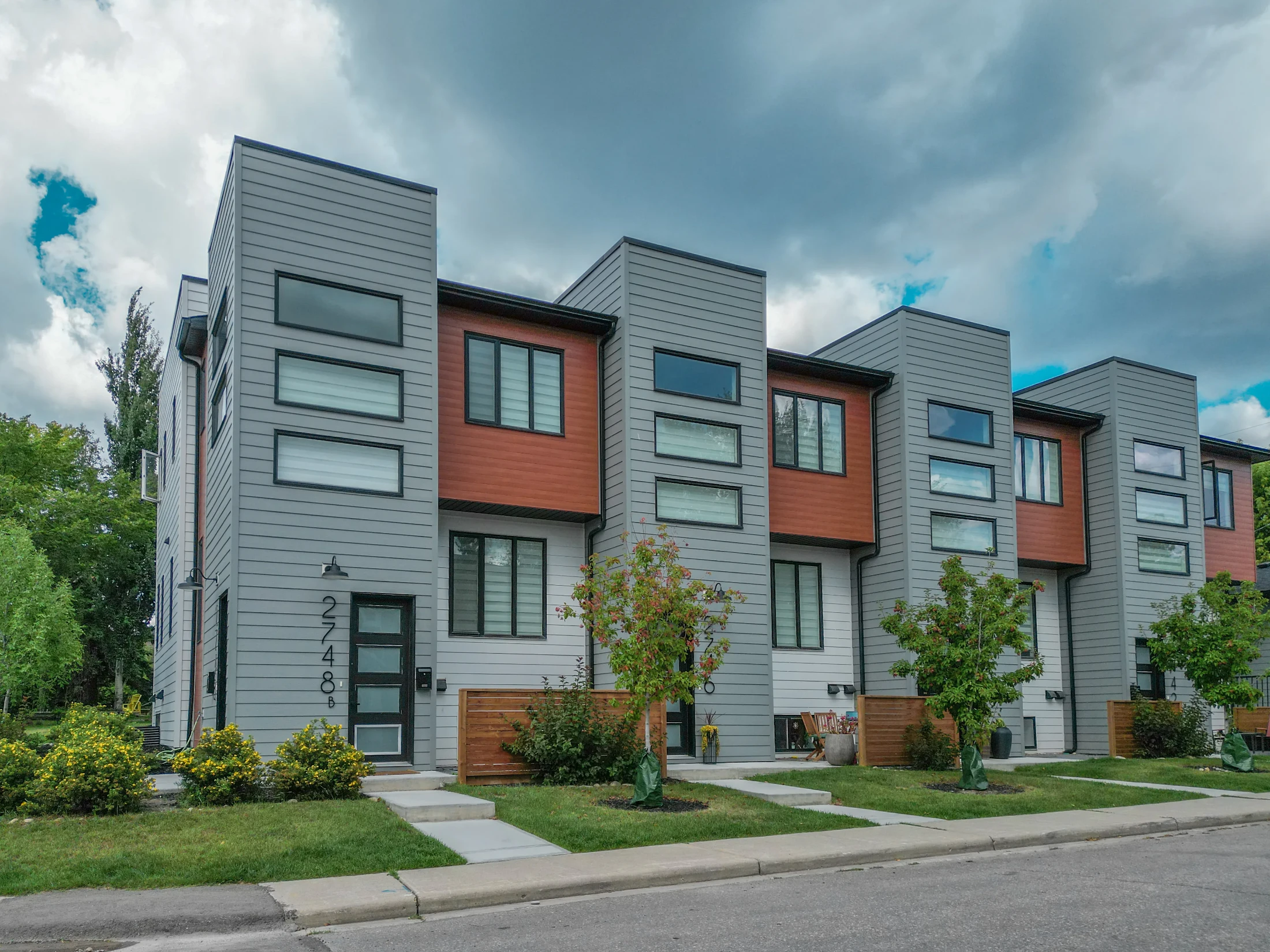 Contemporary row townhomes with dark and wood-look siding