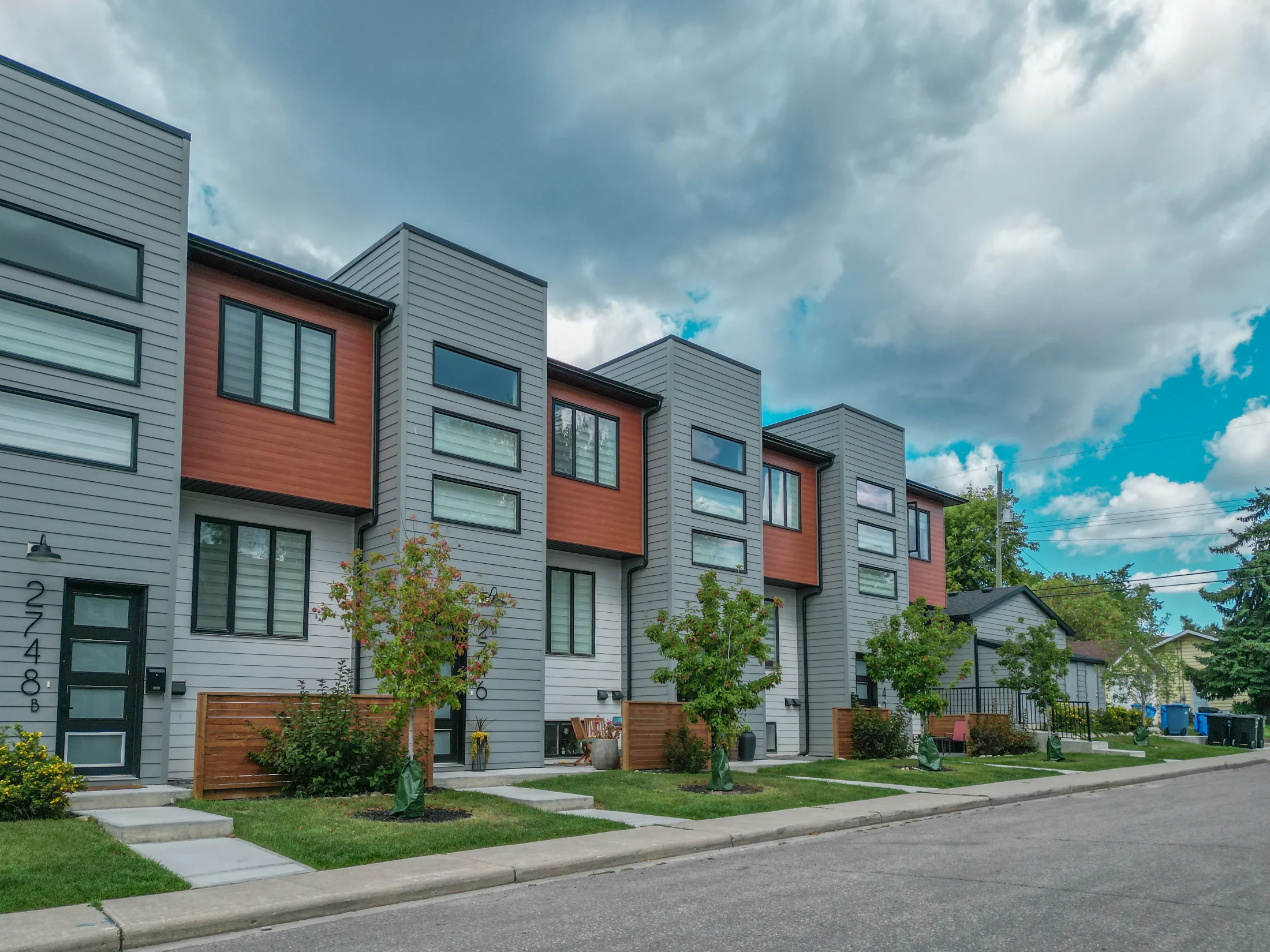 Contemporary townhomes with dark siding on an inner-city corner