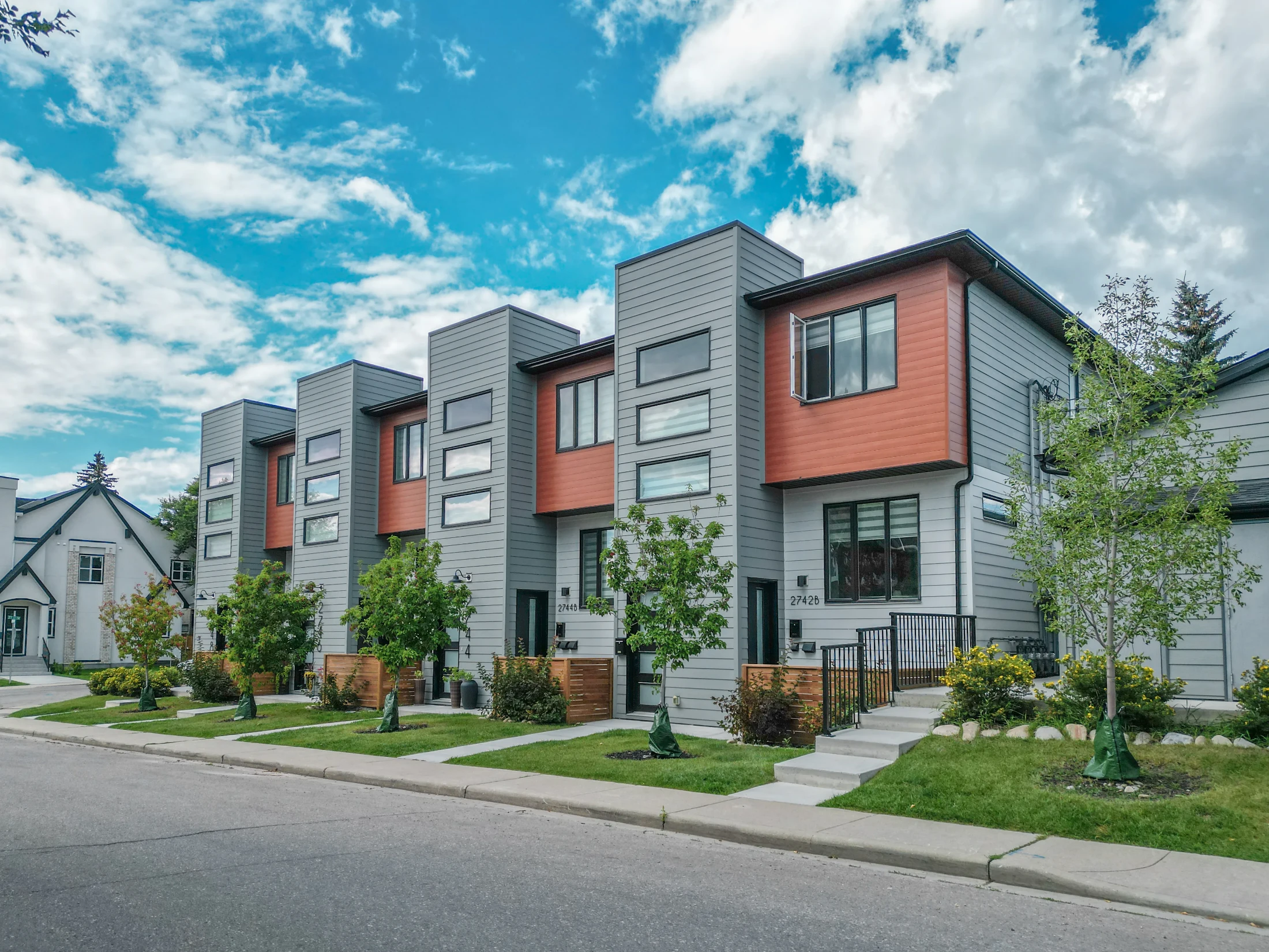 New rowhouses with dark and orange siding in Killarney, Calgary