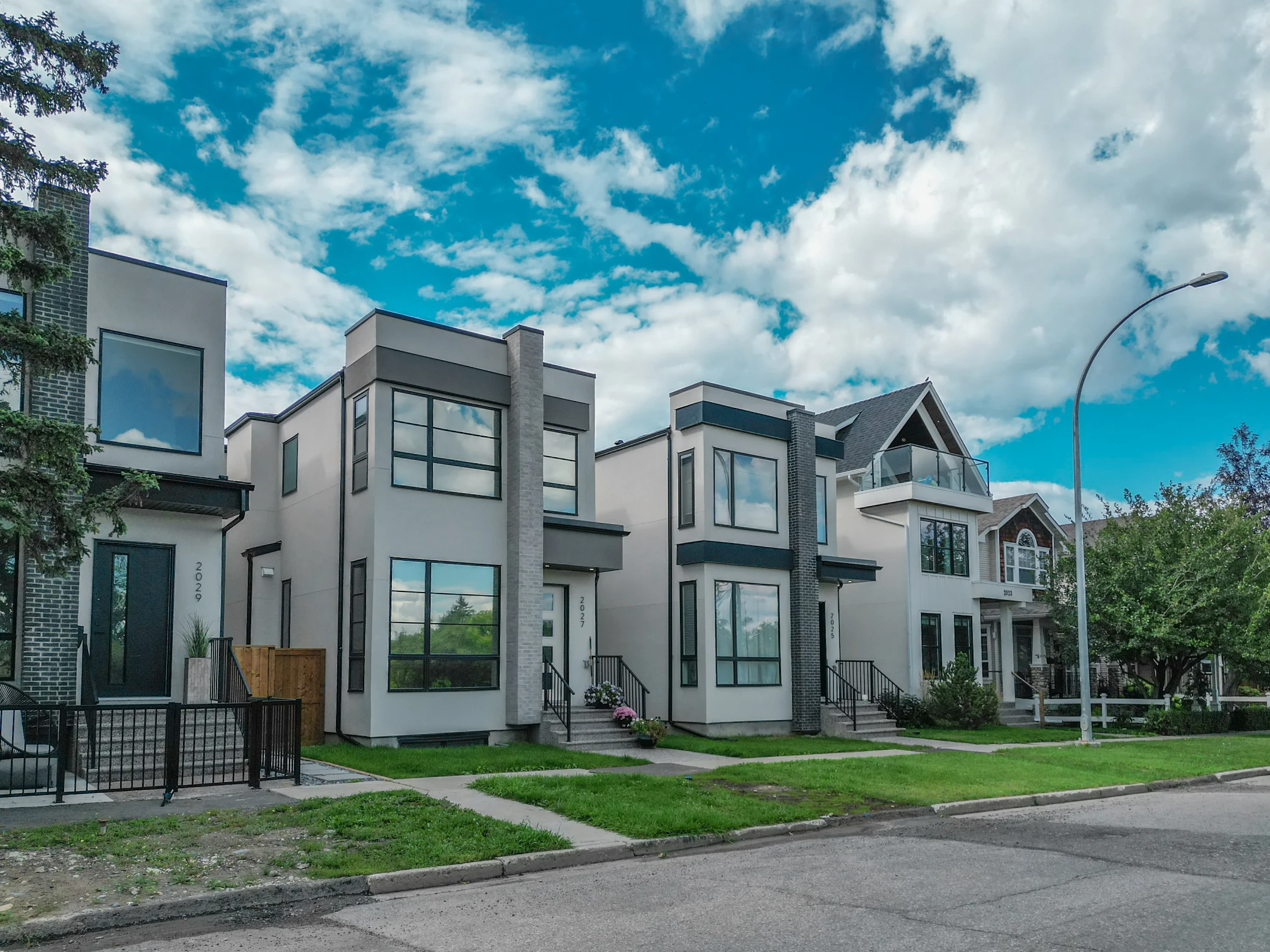 Pair of modern narrow infill homes with front lawns on an inner-city street