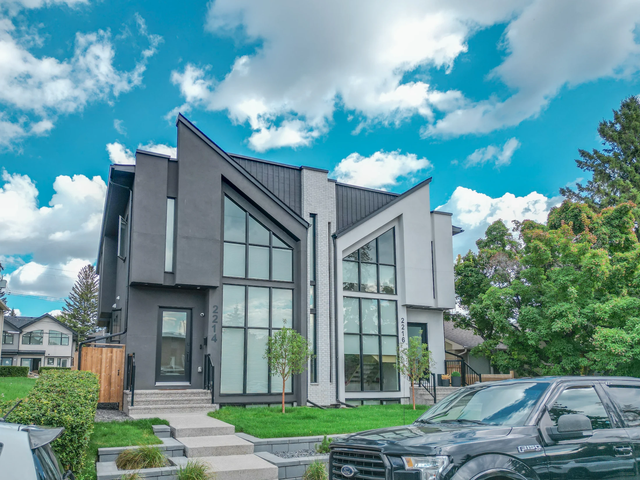 Modern side-by-side infill semi with large windows and a front lawn
