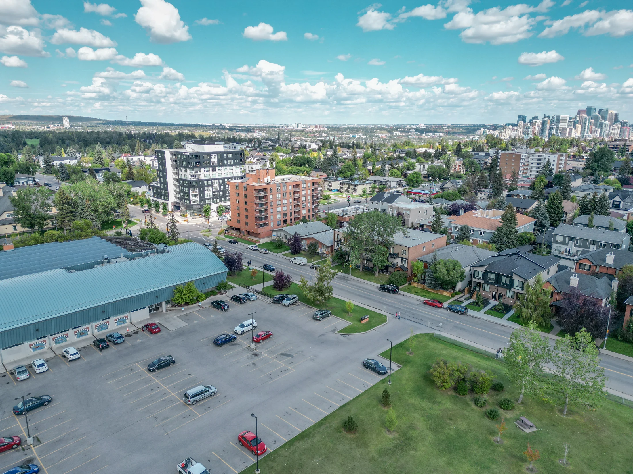 Aerial of Killarney in Calgary with infills, low-rise condos and the downtown skyline