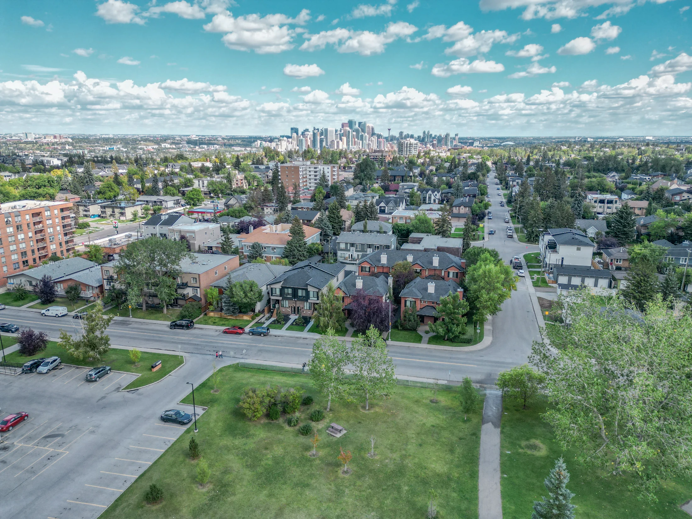 Aerial of a green park surrounded by inner-city homes and low-rise condos