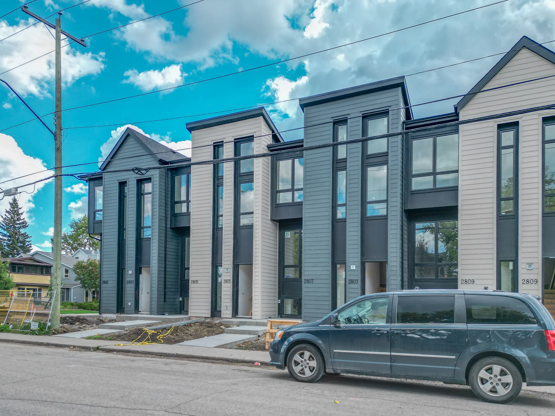 Modern three-storey rowhouse with large windows on an inner-city street