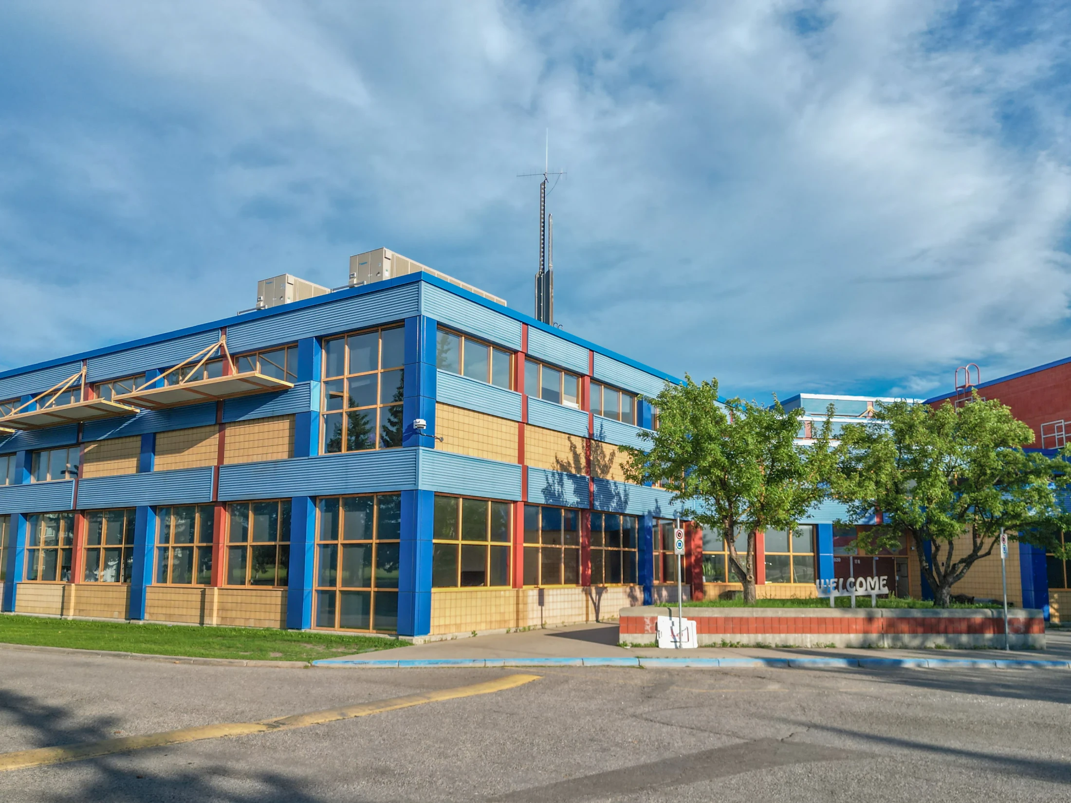 School entrance with blue framed windows and trees