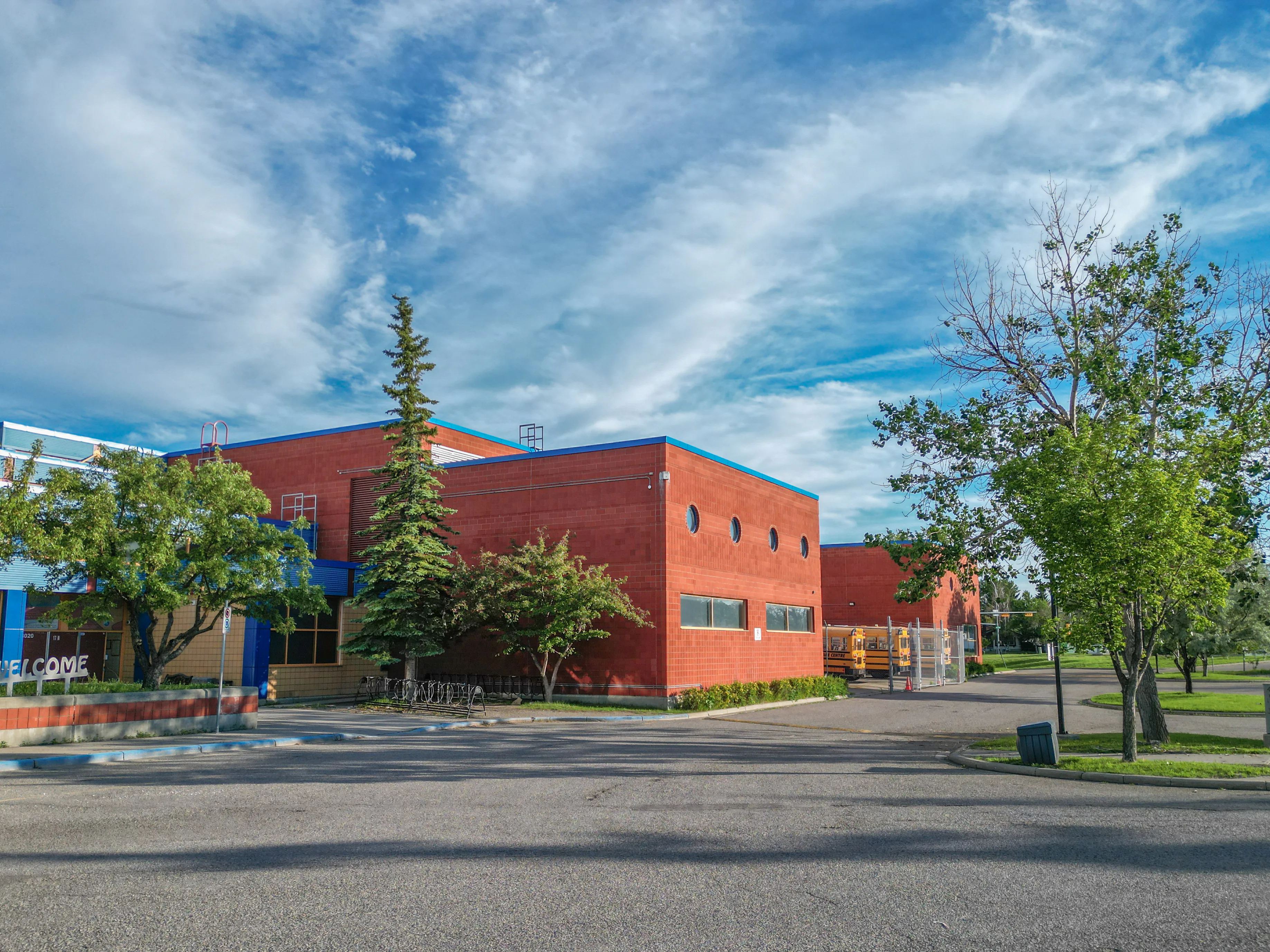 Brick school building with a lawn and young trees