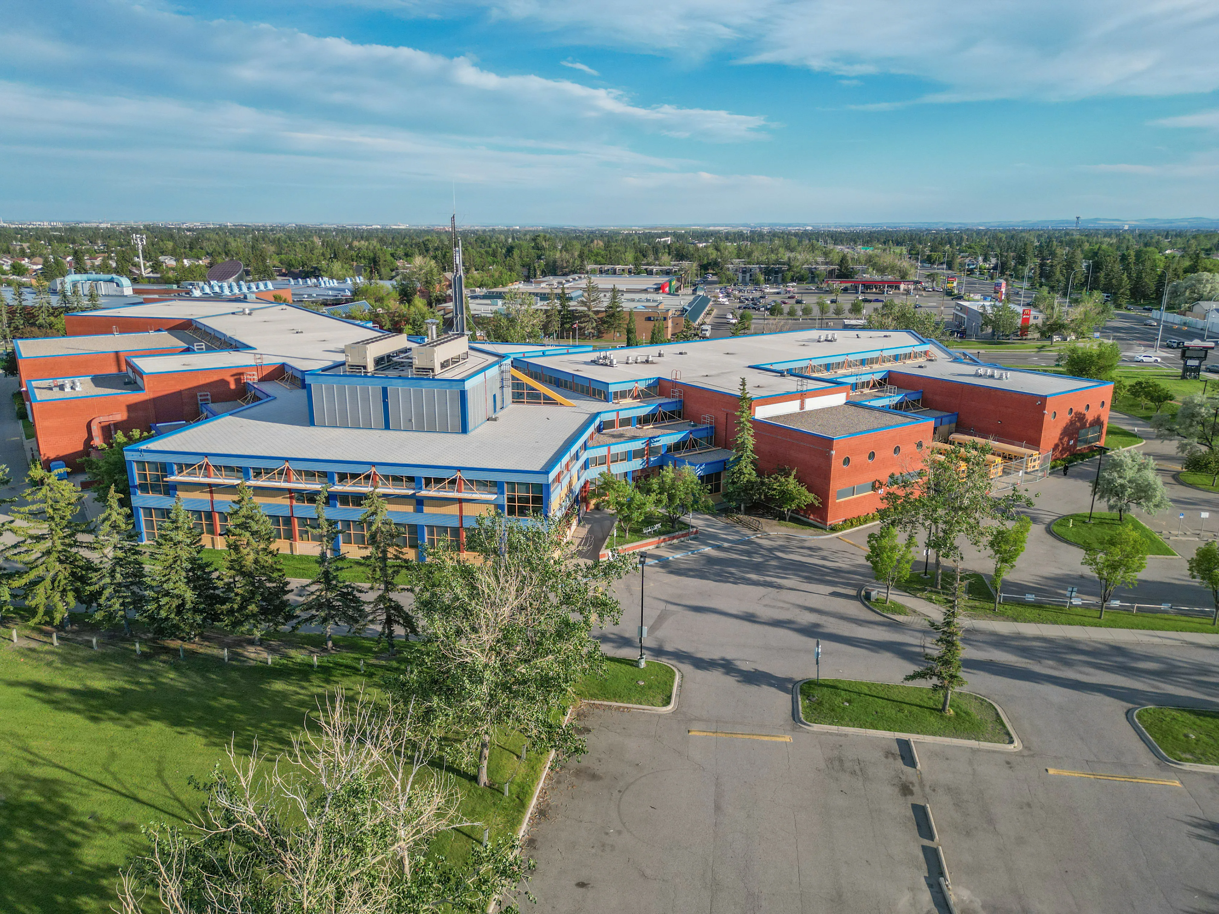 Aerial of a school campus with sports fields and mature trees