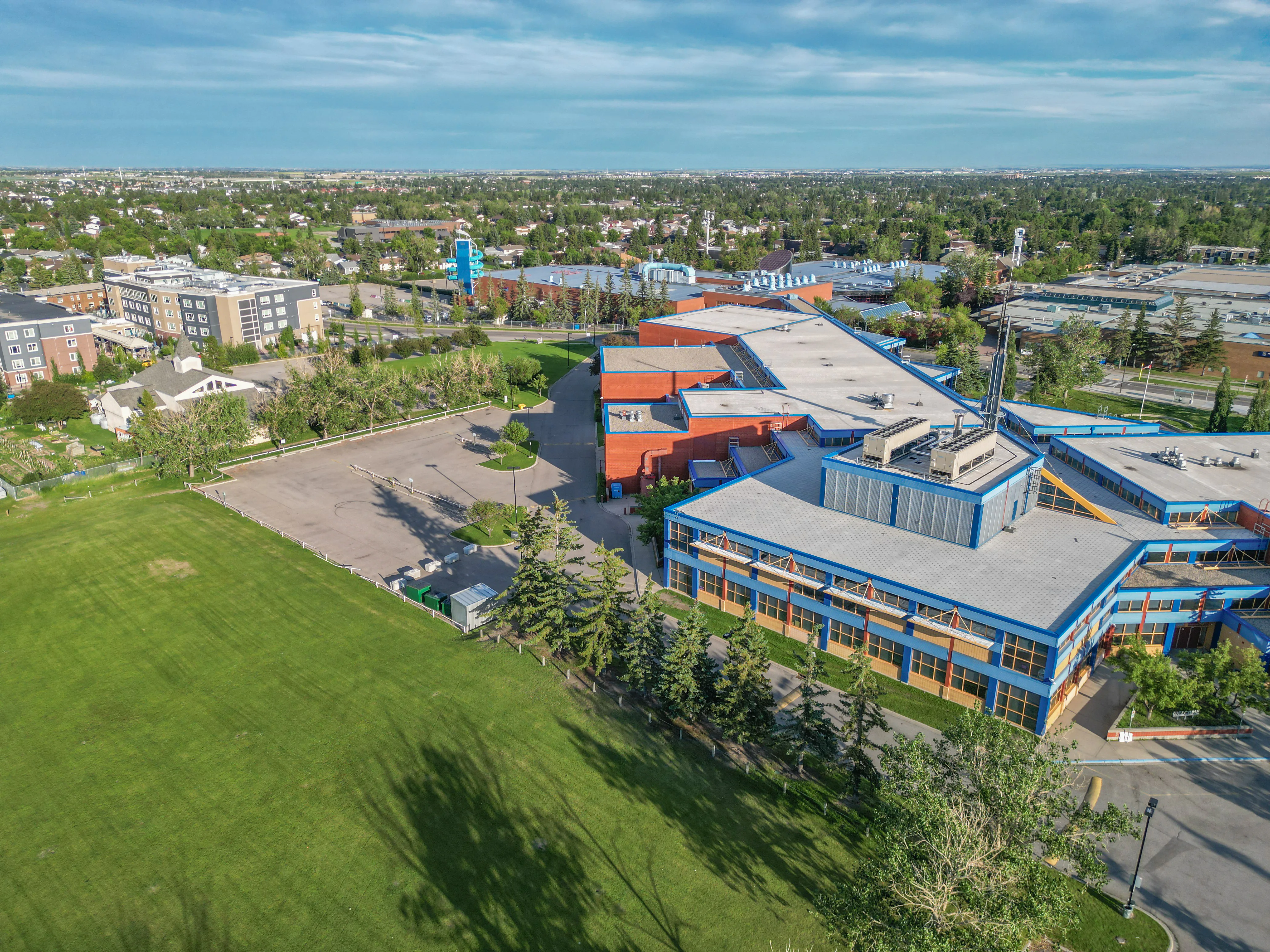 Aerial of a school with a large green field and trees