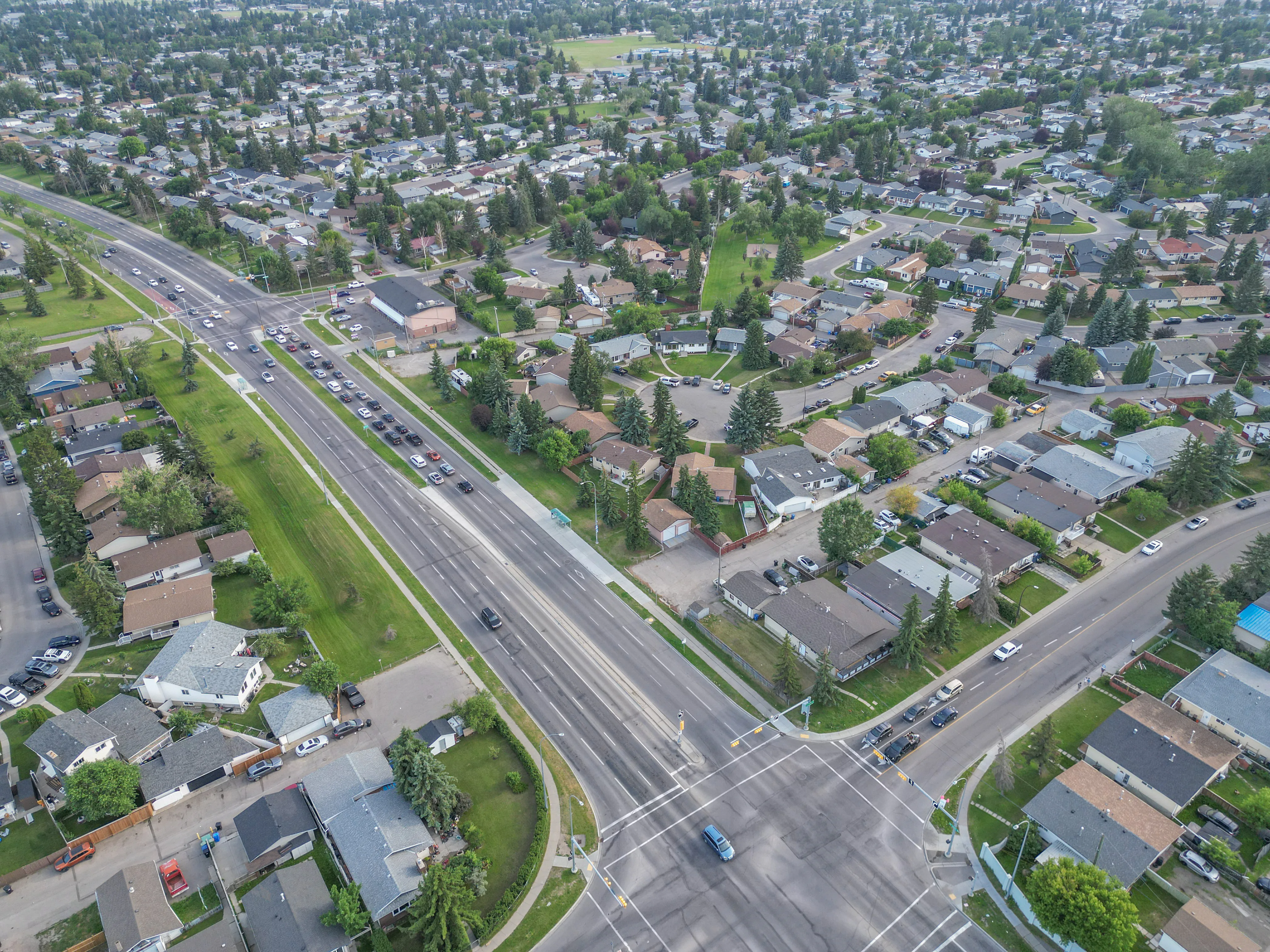 Wide aerial of a residential neighbourhood along a main road