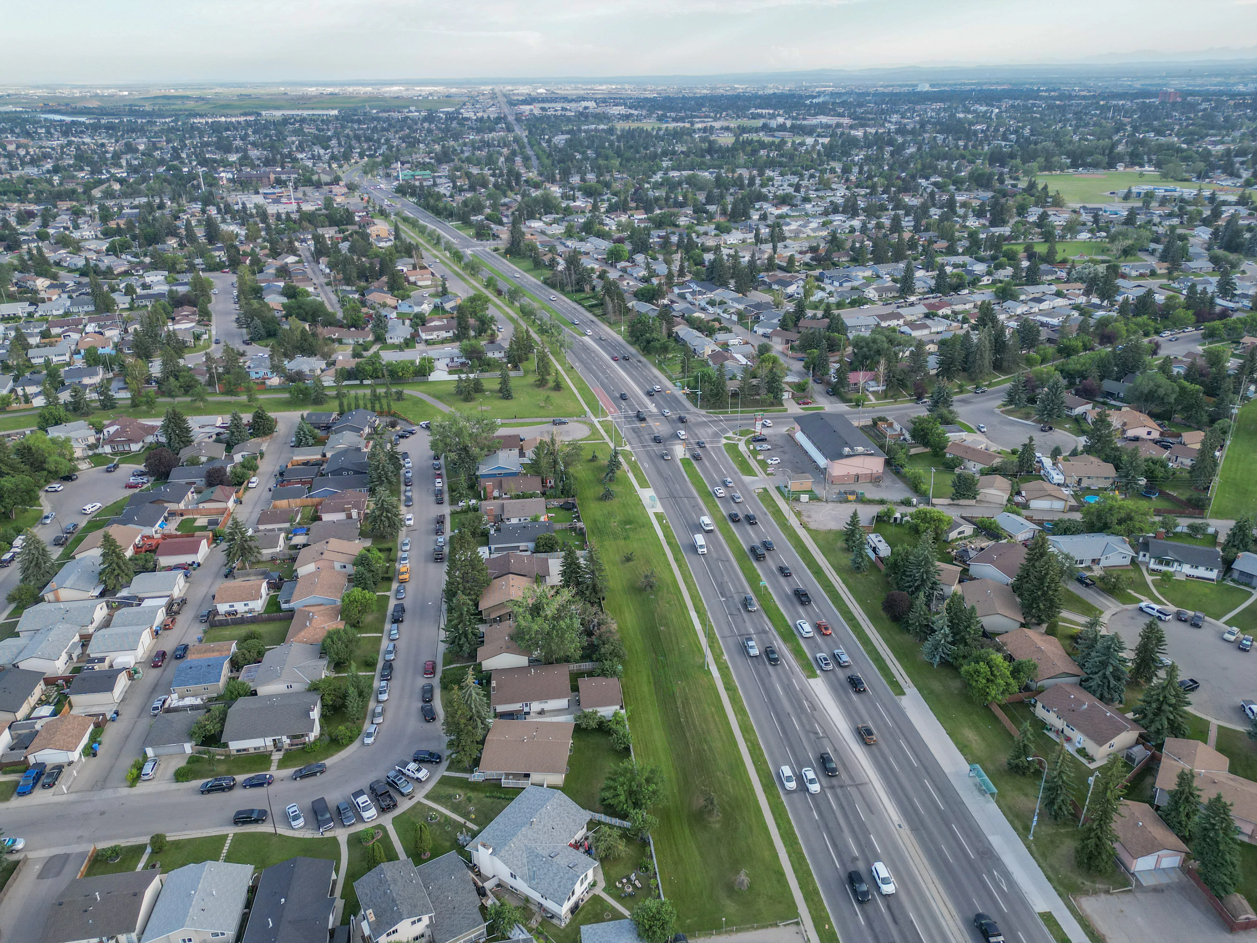 Aerial of homes and a main road with the city in the distance