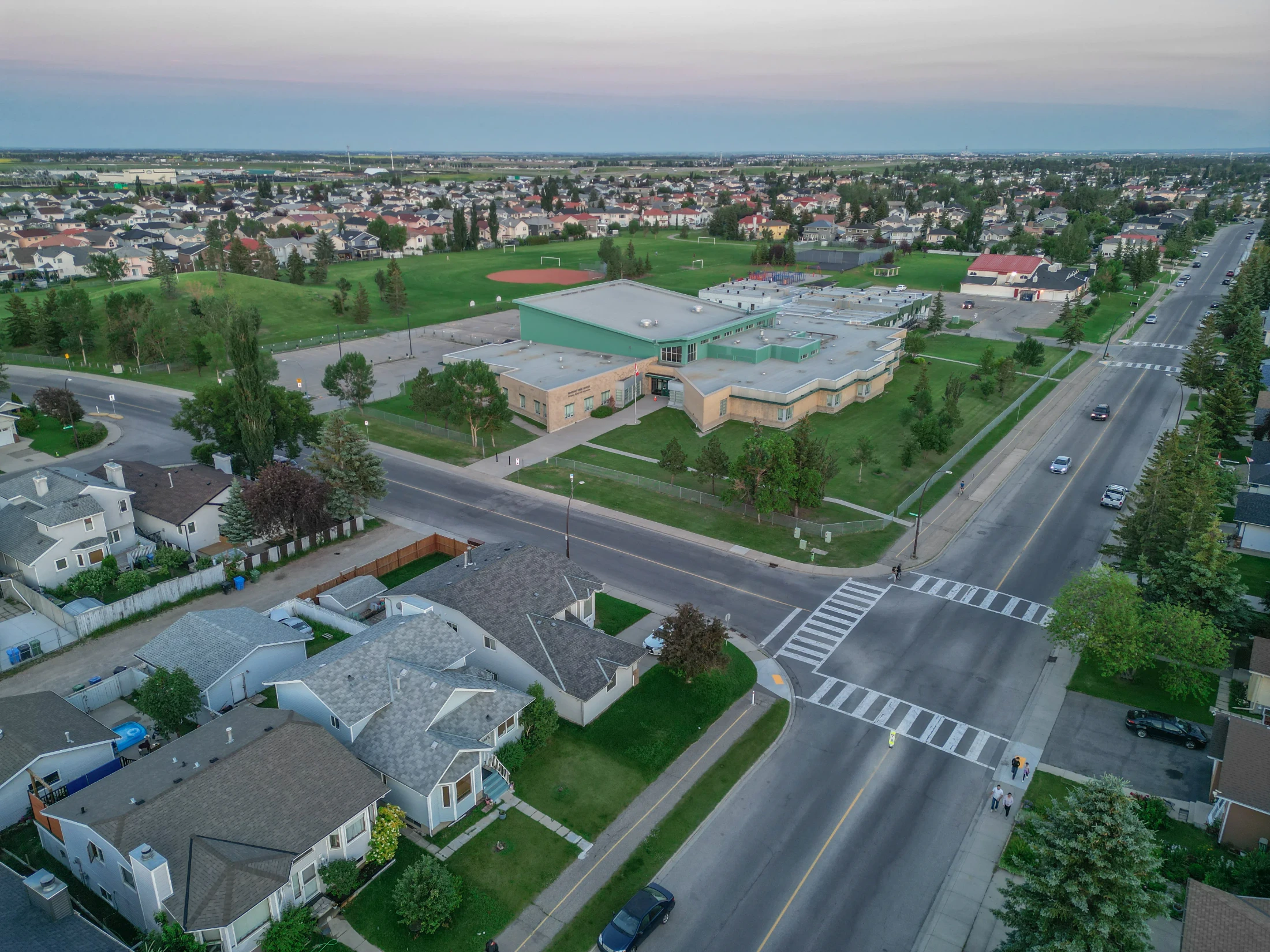 Aerial of a school and playing fields among homes