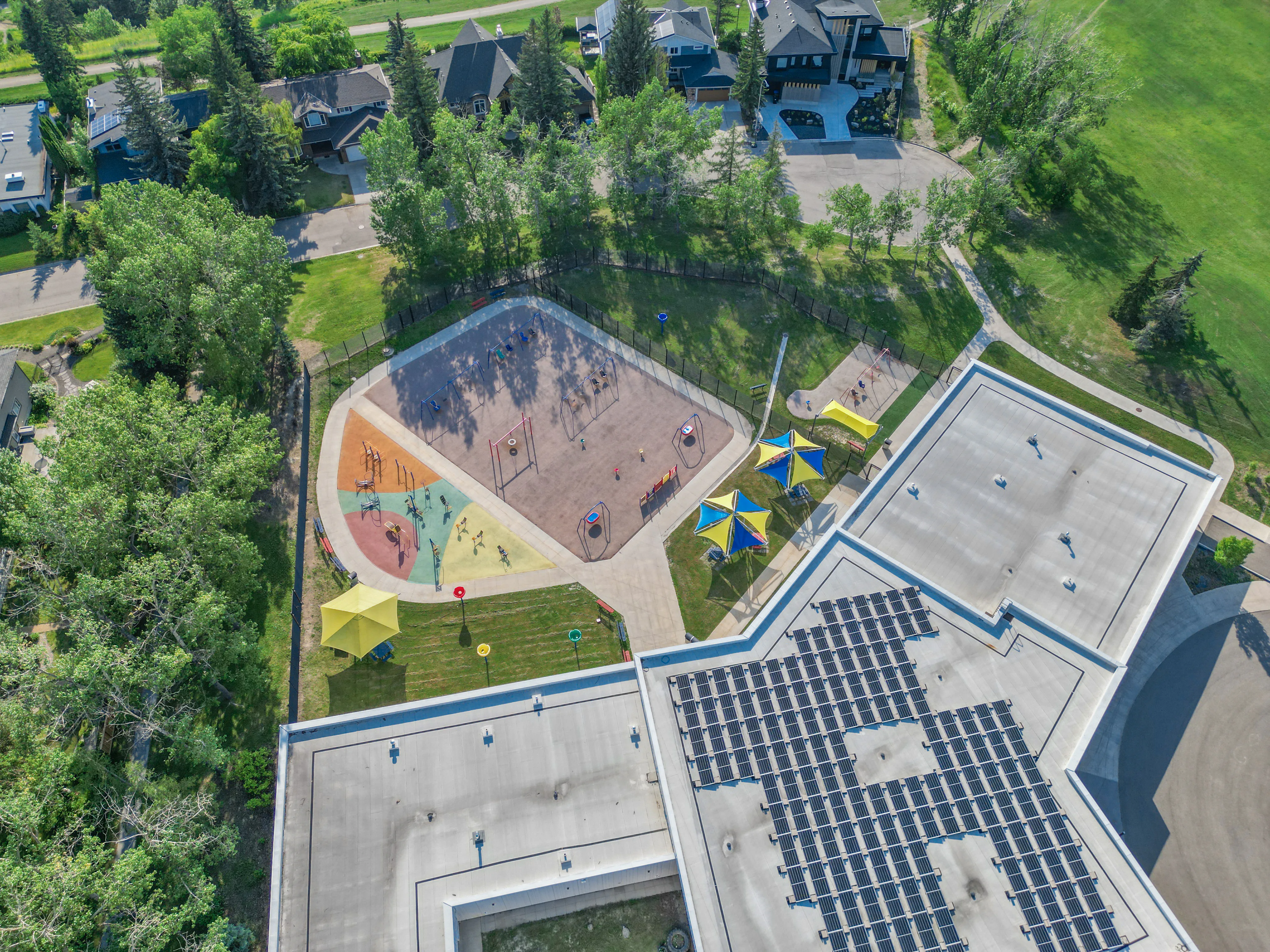 Aerial view of a school playground and mature trees in Montgomery, Calgary