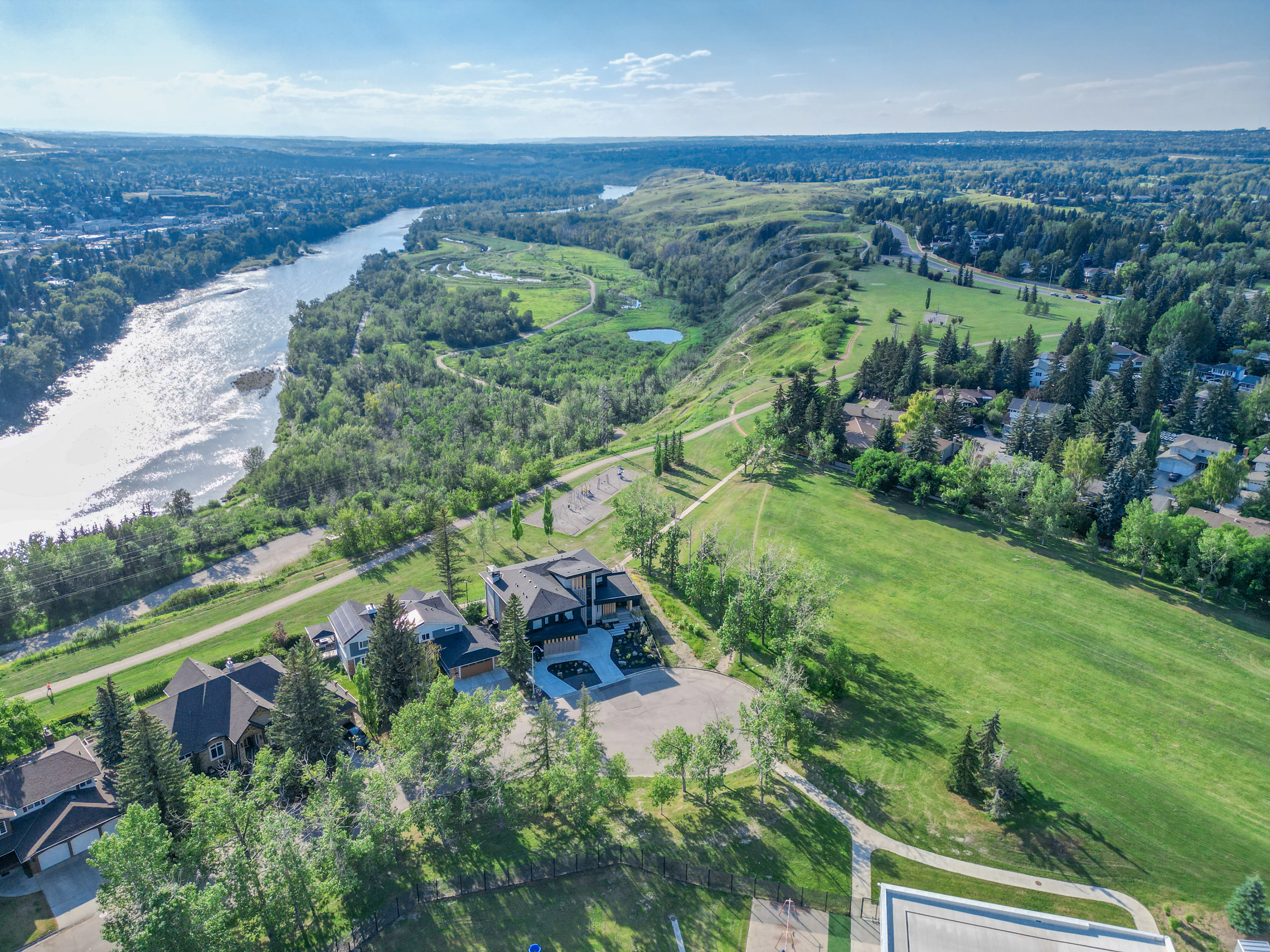 Aerial view of the Bow River valley, green space and established homes in northwest Calgary